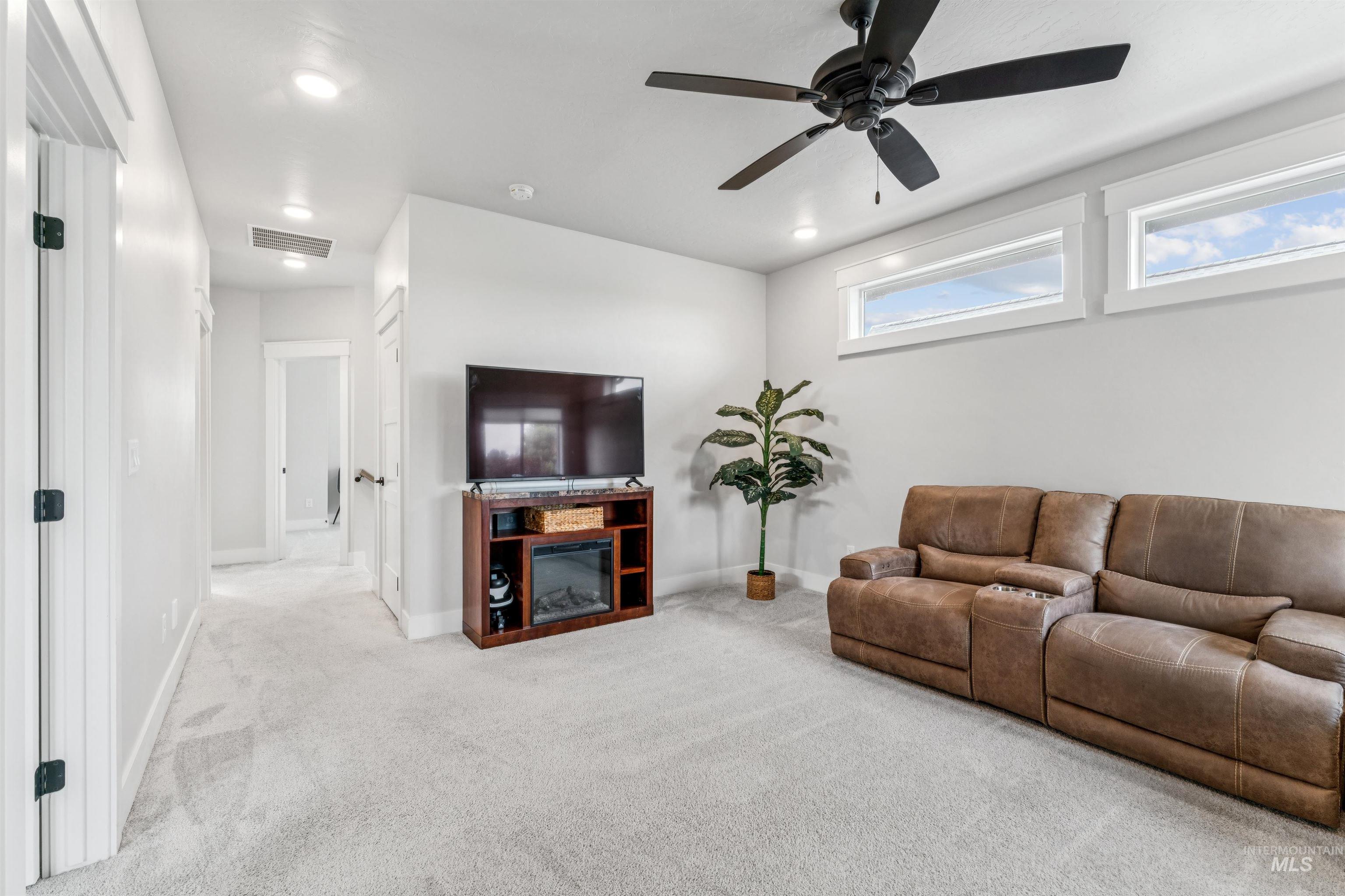Living room with carpet, a ceiling fan, and recessed lighting