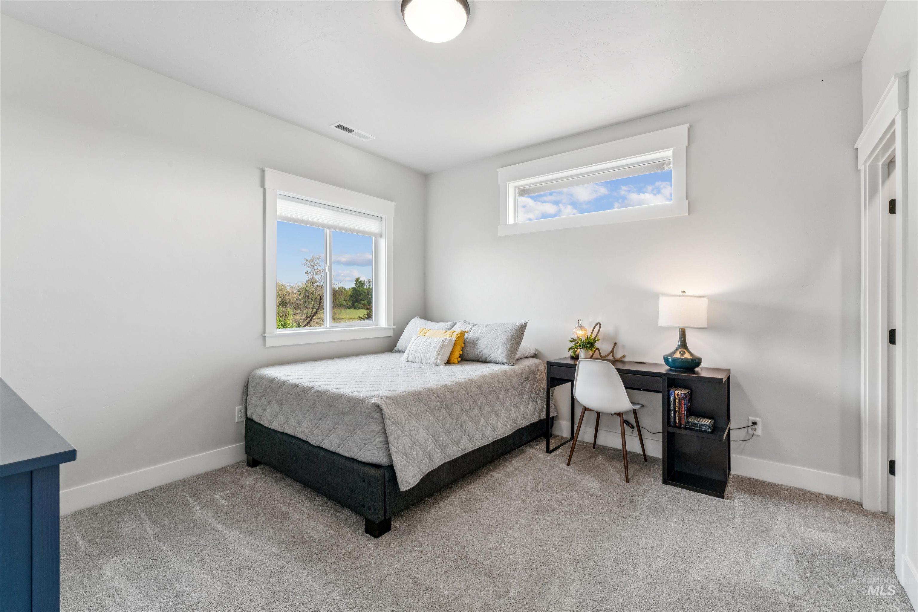 Bedroom with light colored carpet and baseboards