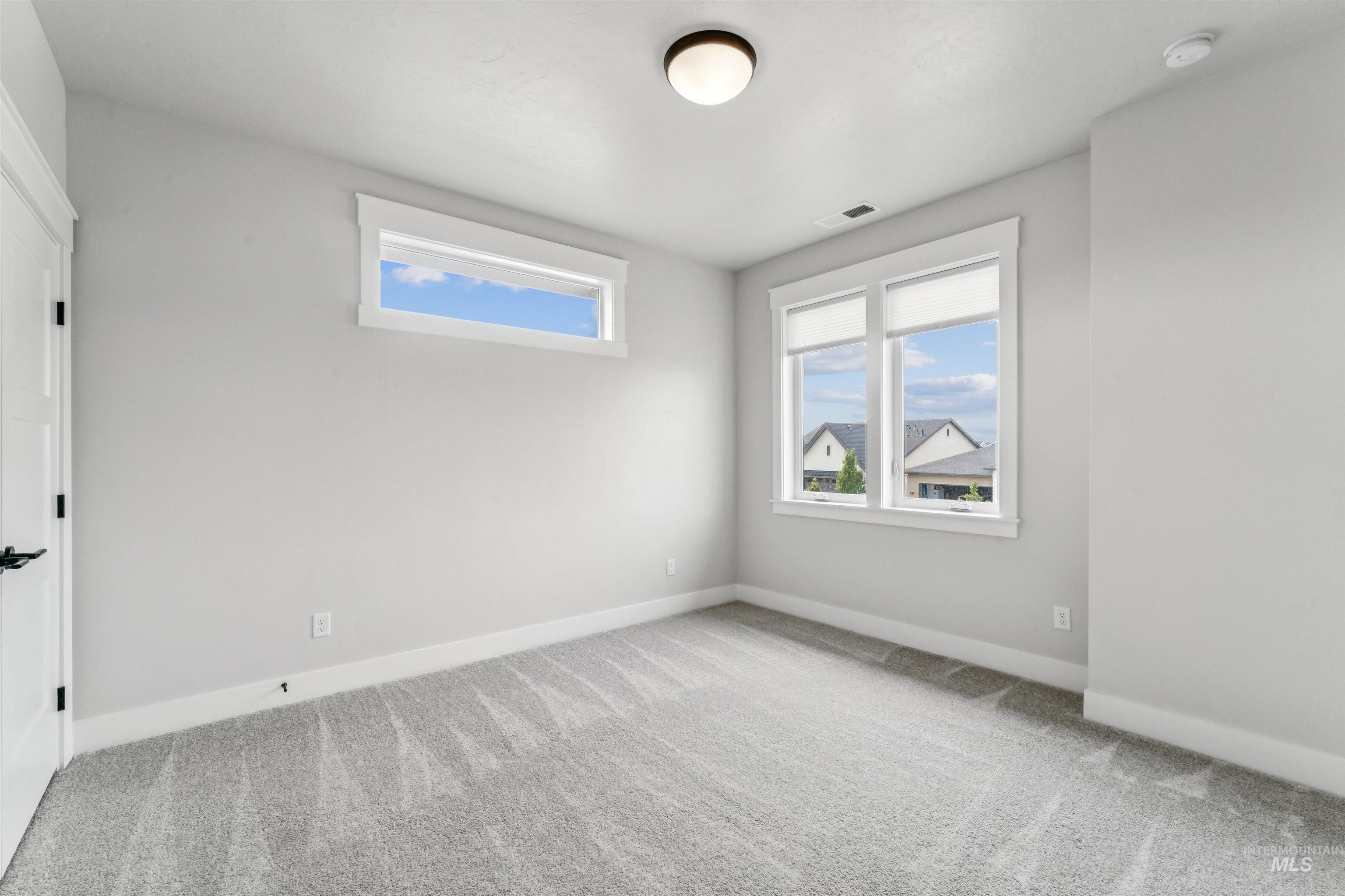 Spare room with light colored carpet and baseboards