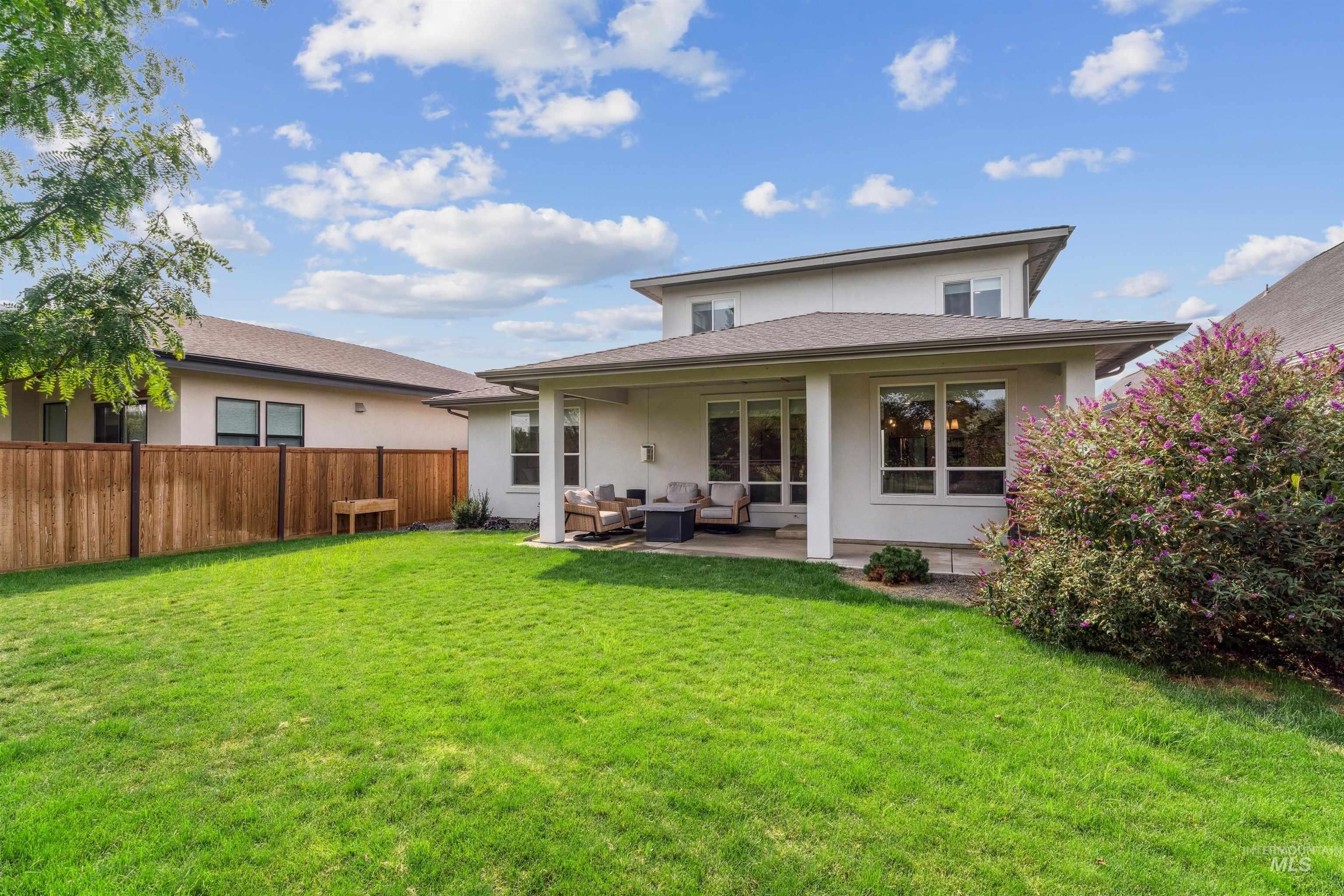 Back of house with stucco siding, an outdoor hangout area, and a patio