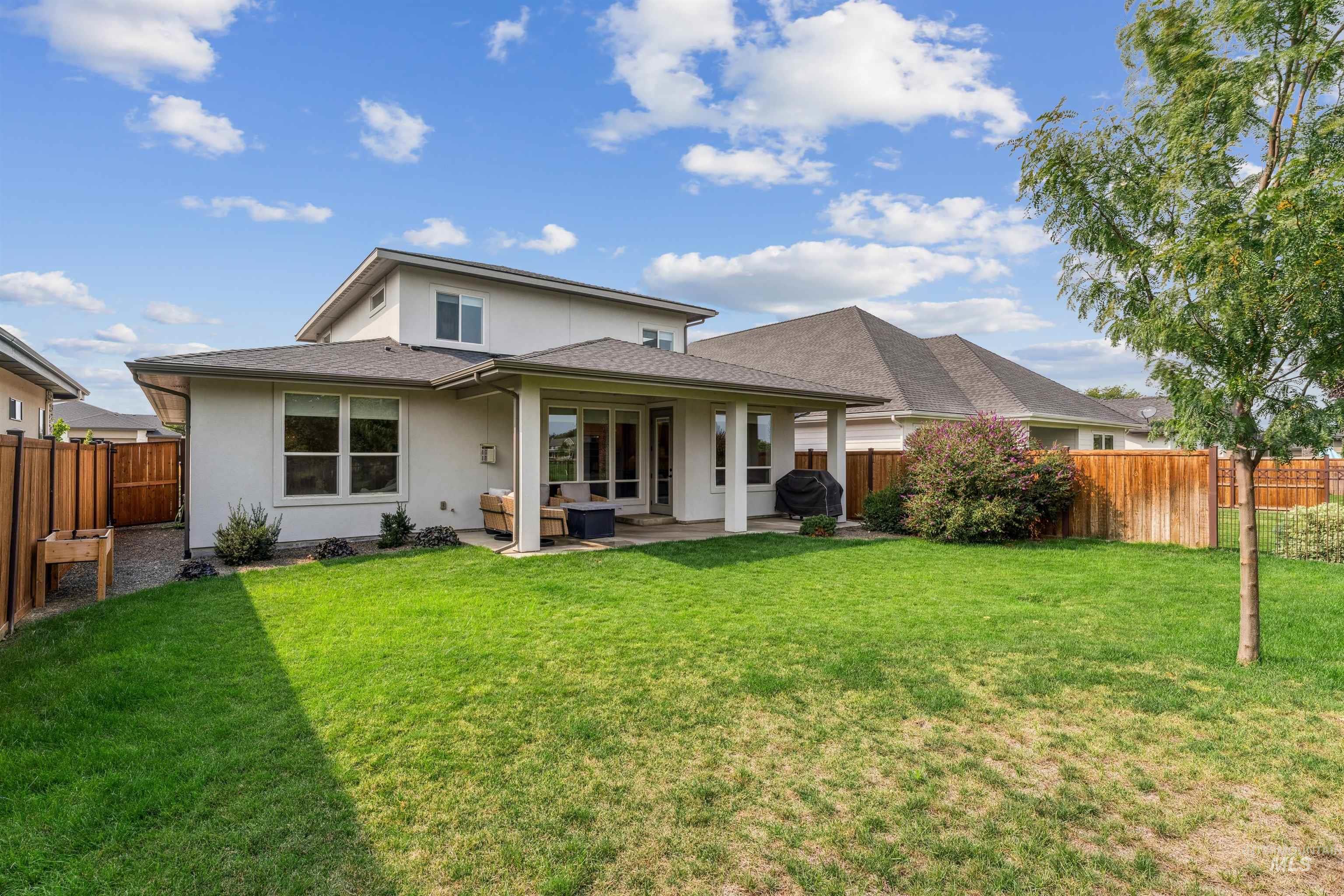 Back of property with a patio area, a fenced backyard, stucco siding, and a shingled roof