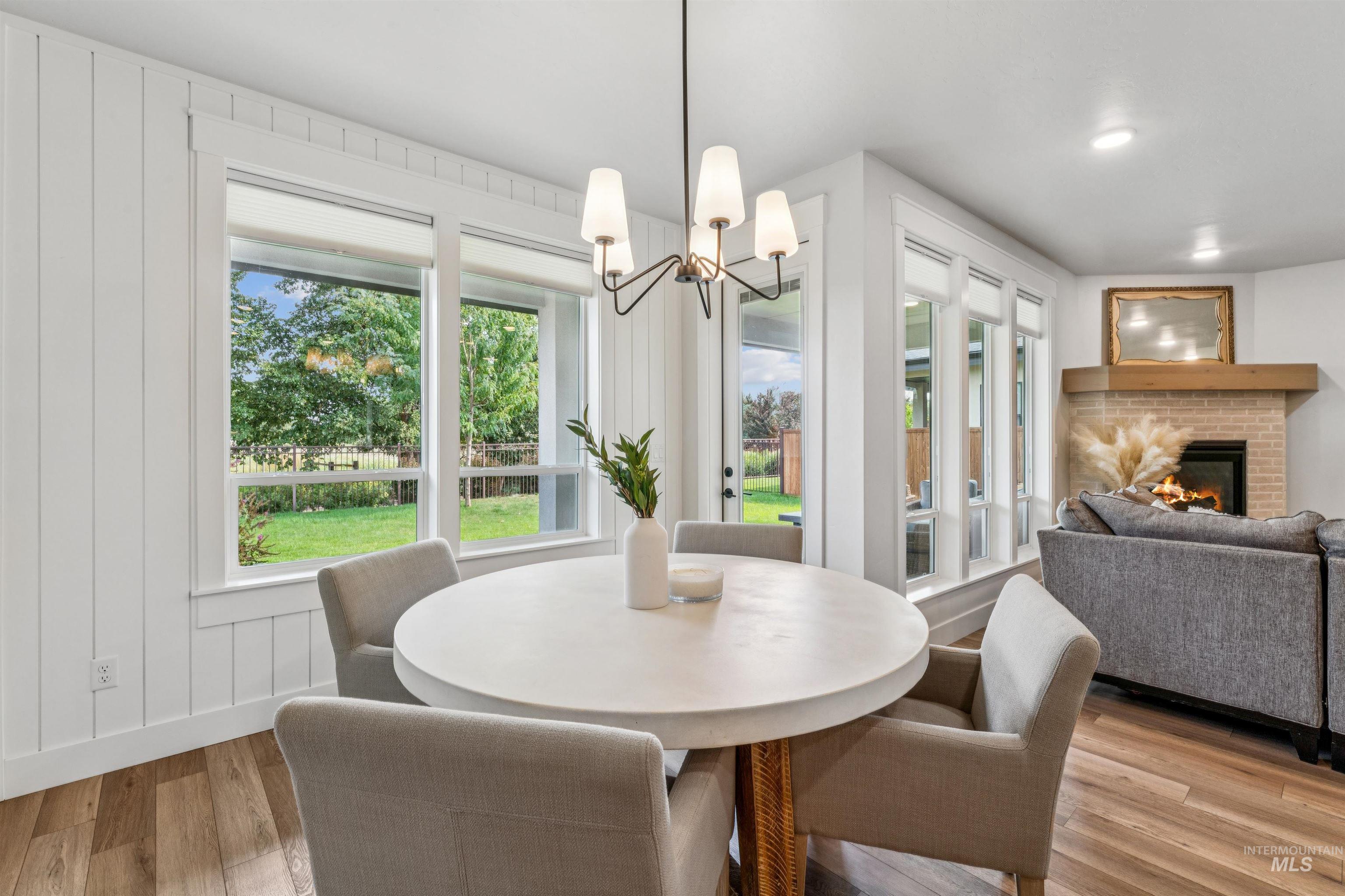 Dining space featuring a fireplace, light wood-type flooring, and a chandelier
