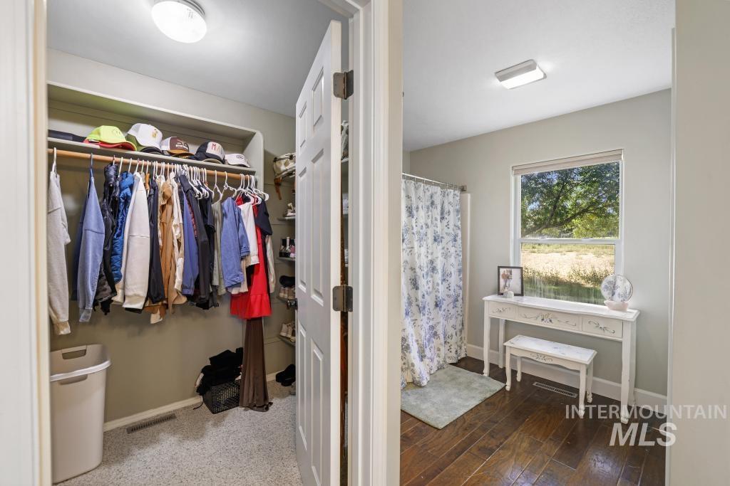 Walk in closet featuring dark wood-type flooring