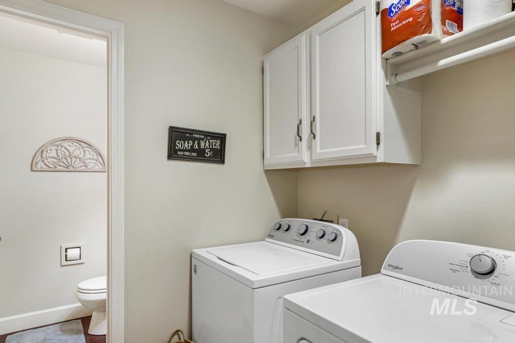 Washroom with cabinet space and washing machine and clothes dryer