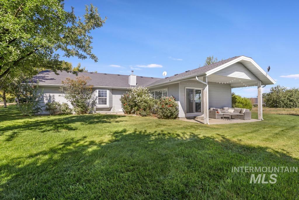 Rear view of house featuring an outdoor hangout area, a patio area, a lawn, and a chimney