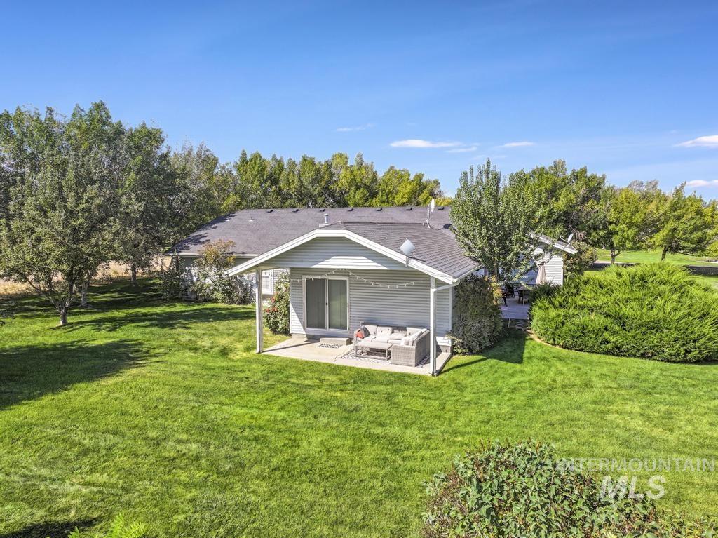 Back of house with an outdoor hangout area, a lawn, and a patio area