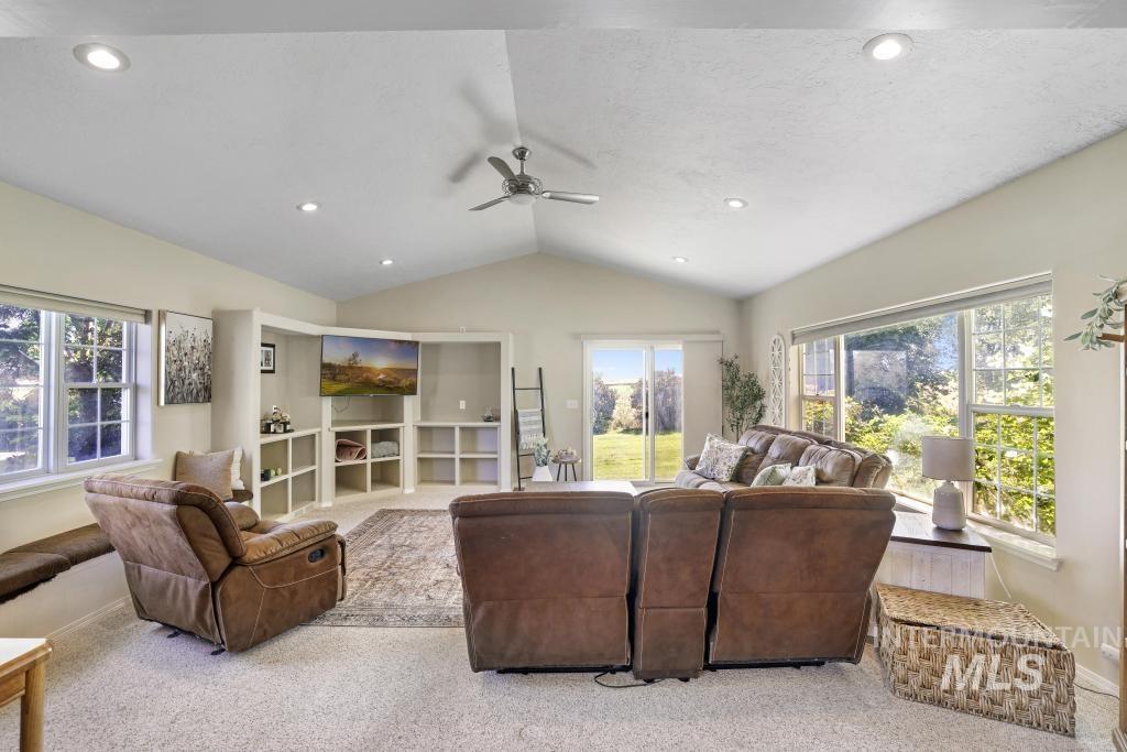 Living room with carpet floors, vaulted ceiling, a ceiling fan, and recessed lighting