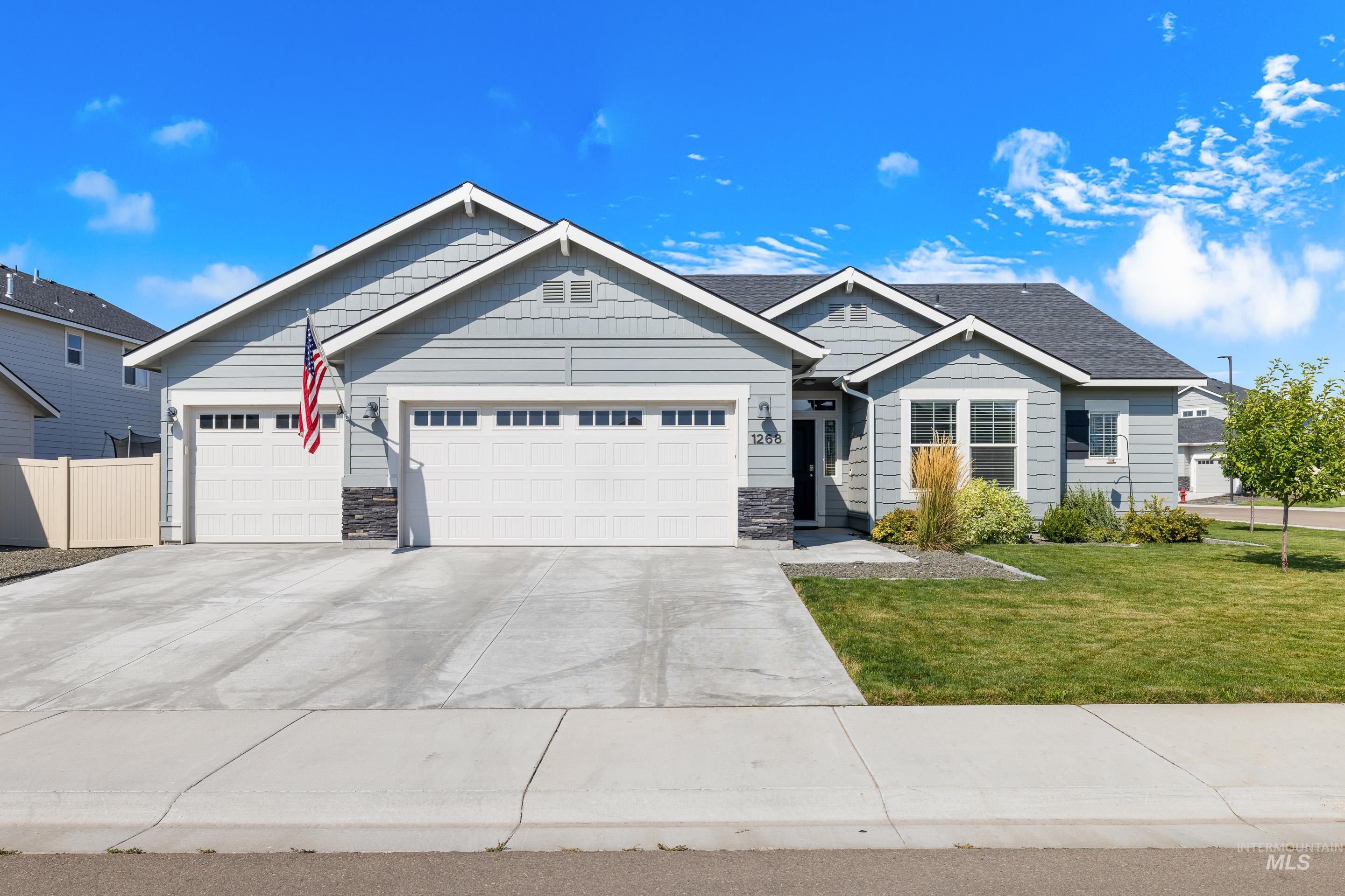 View of front of house featuring stone siding, driveway, and a garage