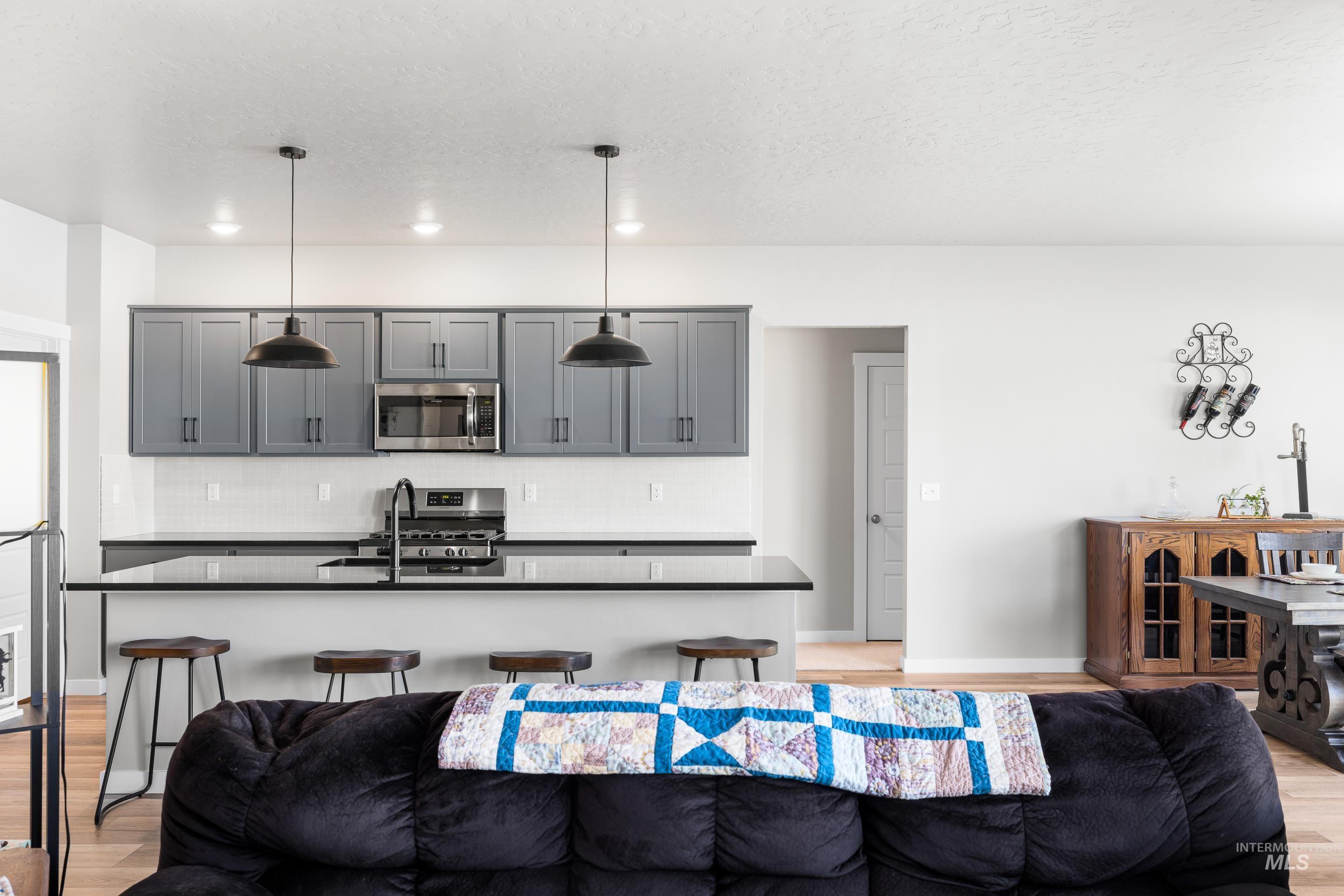 Living area with light wood-style flooring, a textured ceiling, and recessed lighting