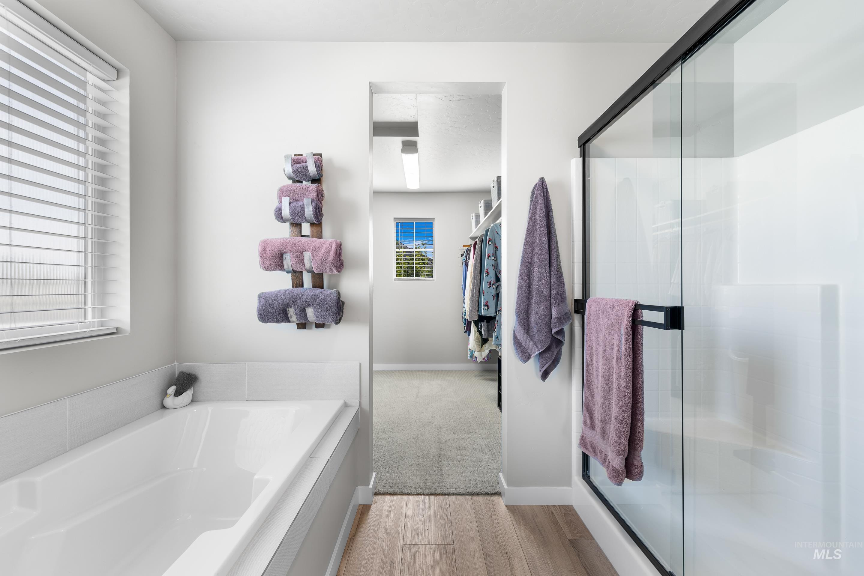 Full bathroom with a garden tub, plenty of natural light, and a shower stall