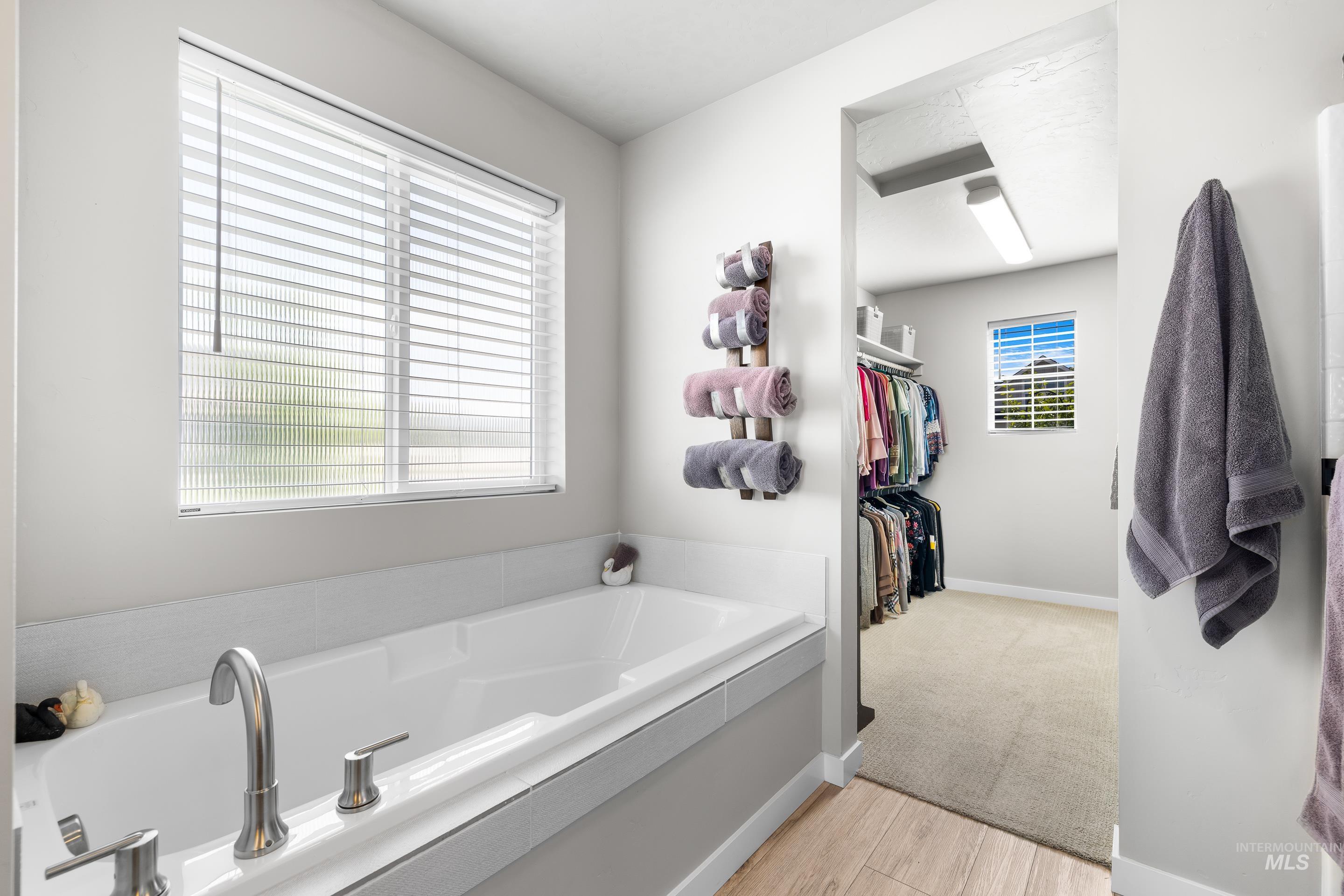 Bathroom featuring a bath and a walk in closet