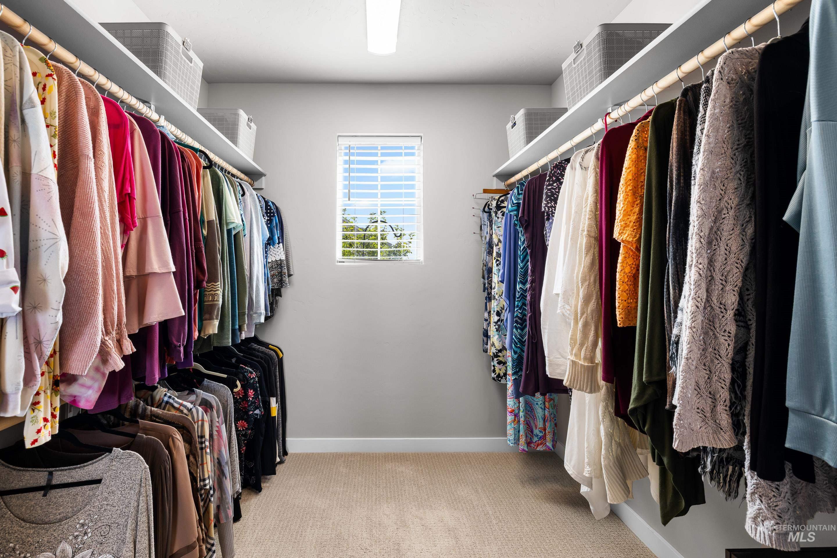 Spacious closet featuring light colored carpet