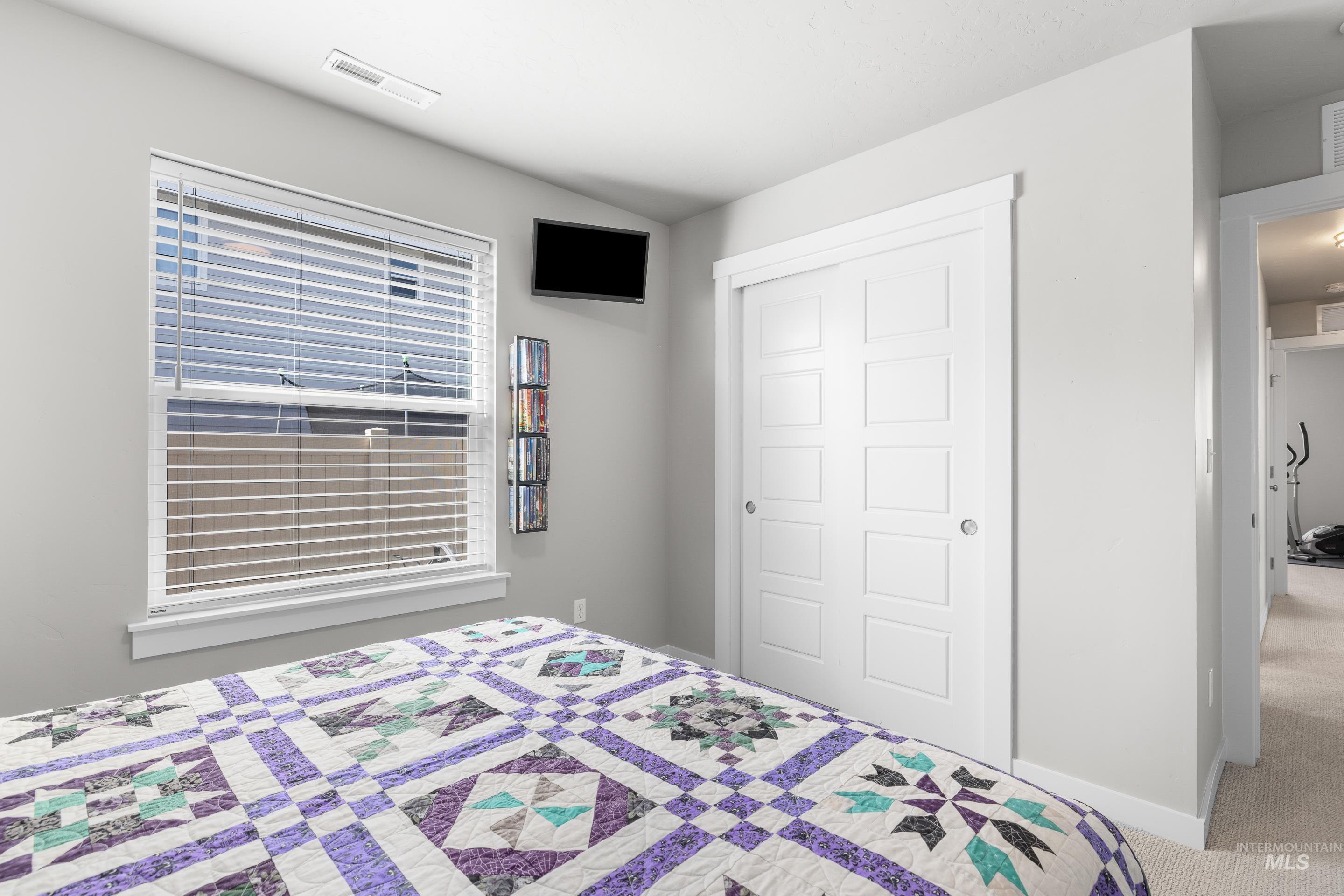 Carpeted bedroom featuring baseboards and a closet