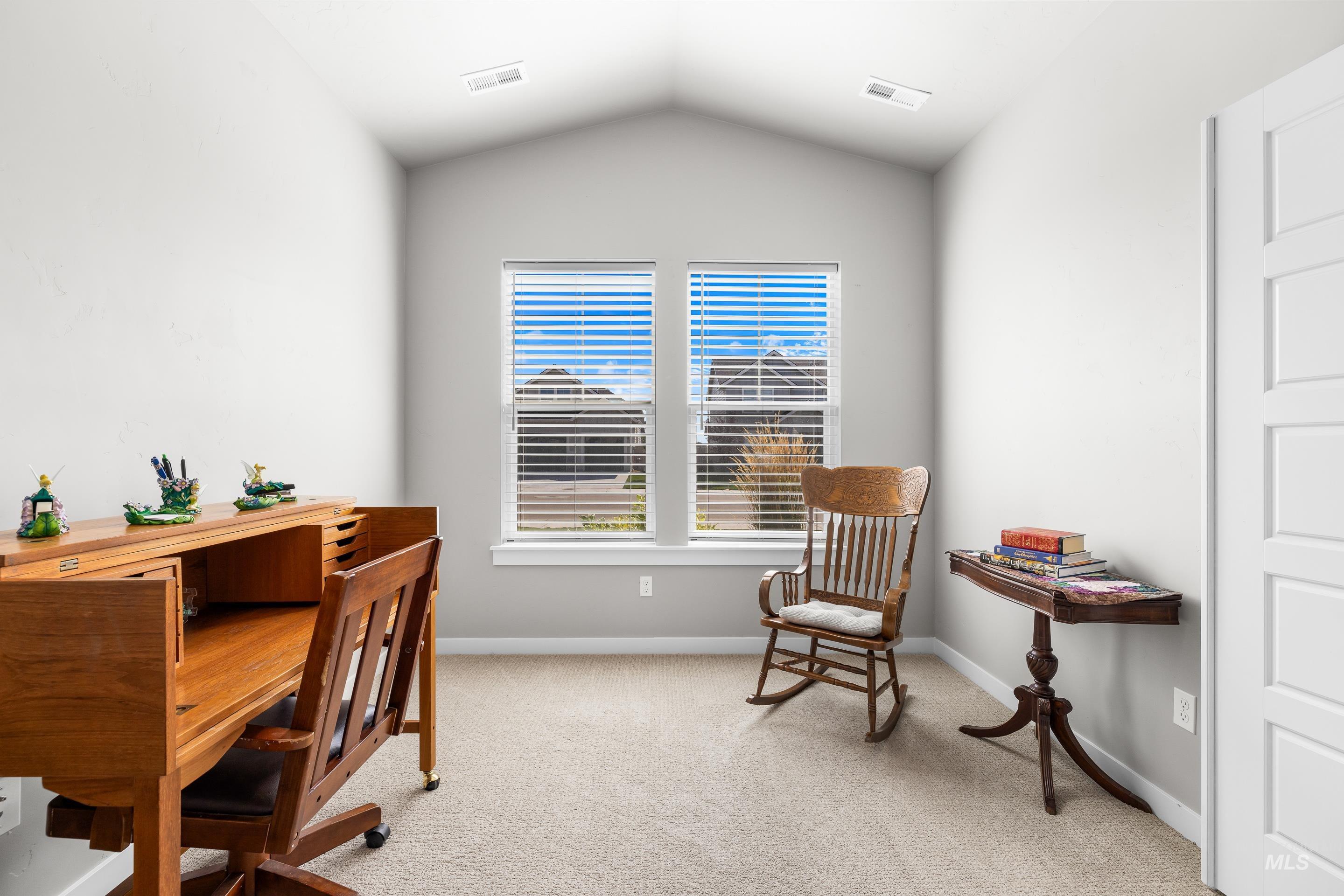 Office area featuring light colored carpet and lofted ceiling