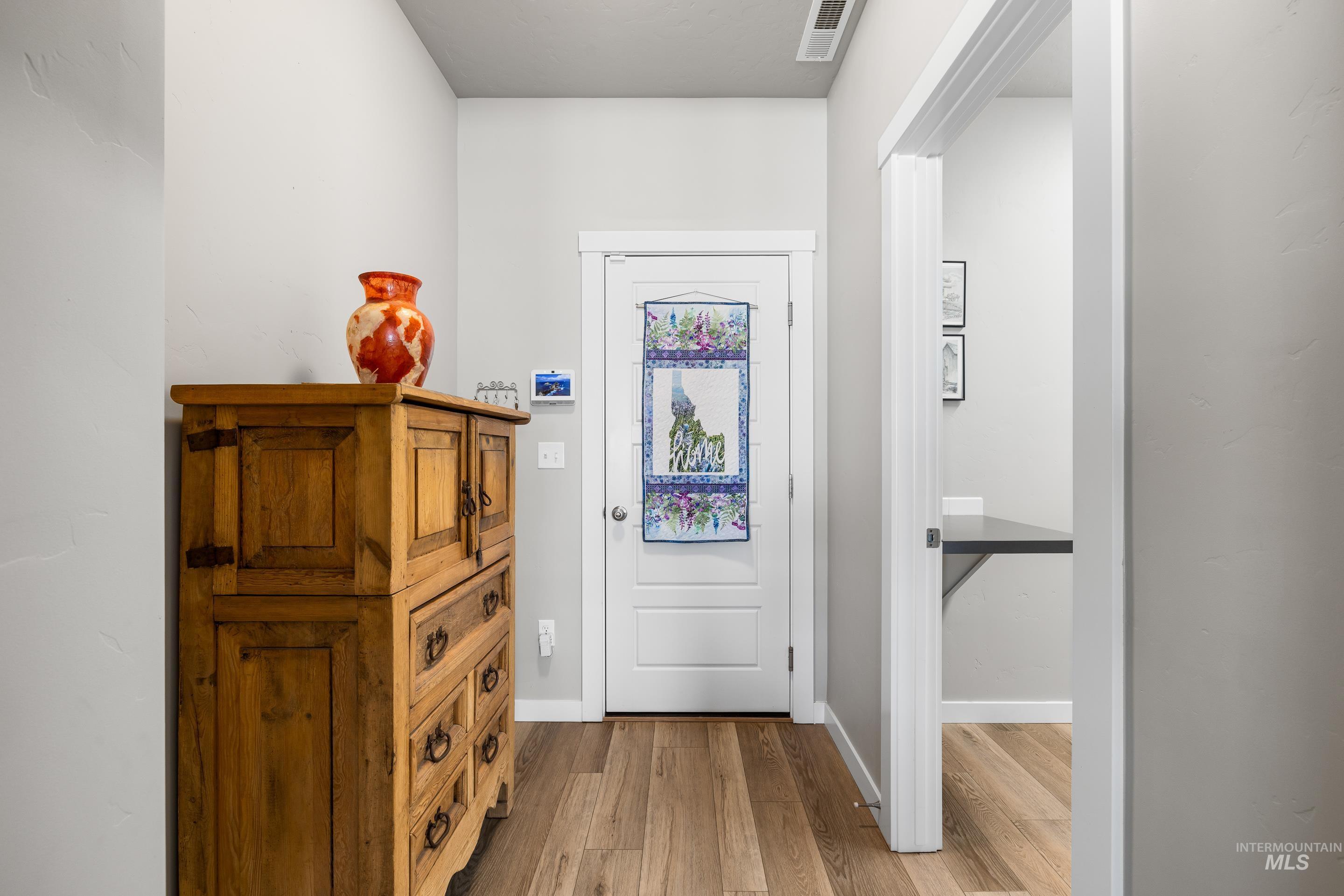 Doorway featuring wood finished floors and baseboards