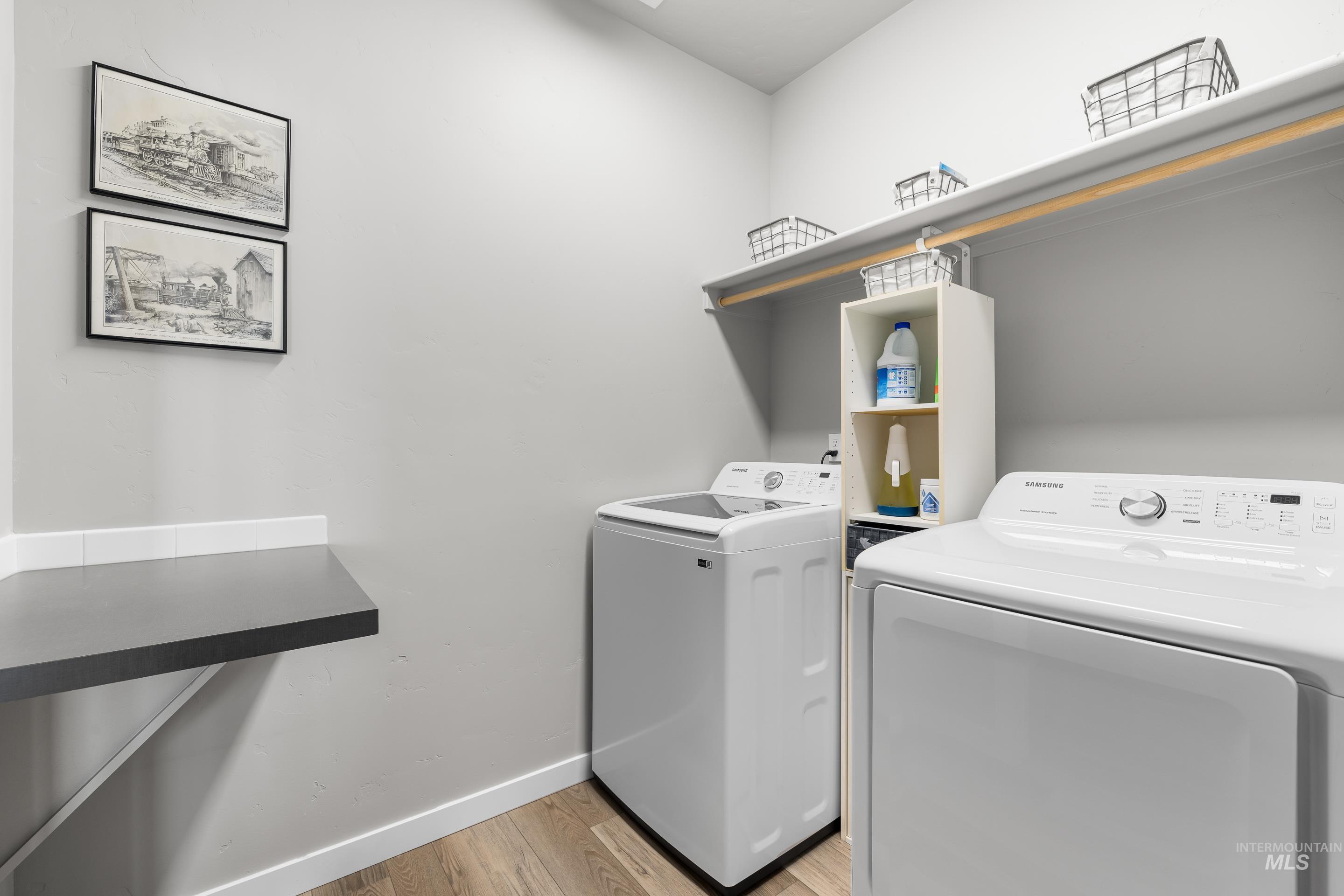 Washroom featuring washing machine and dryer and light wood-style floors