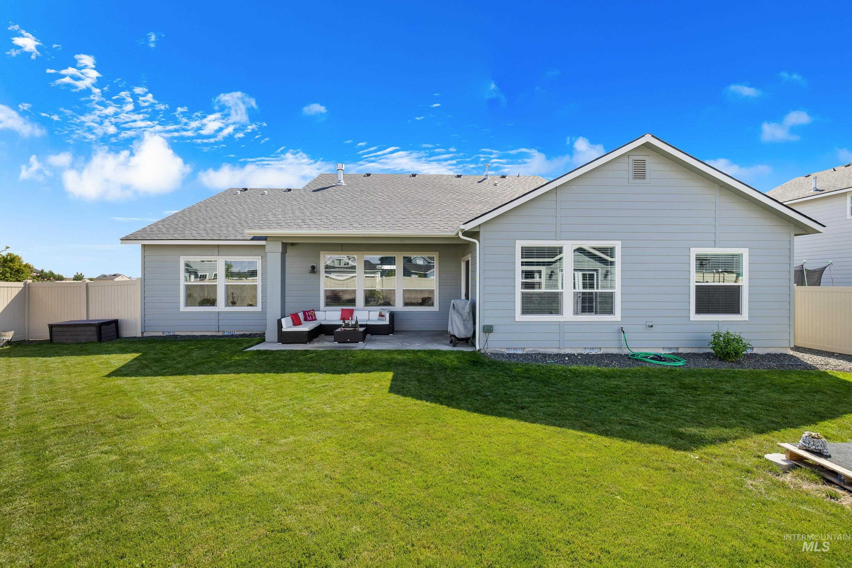 Rear view of house with a fenced backyard, a patio, a shingled roof, and outdoor lounge area