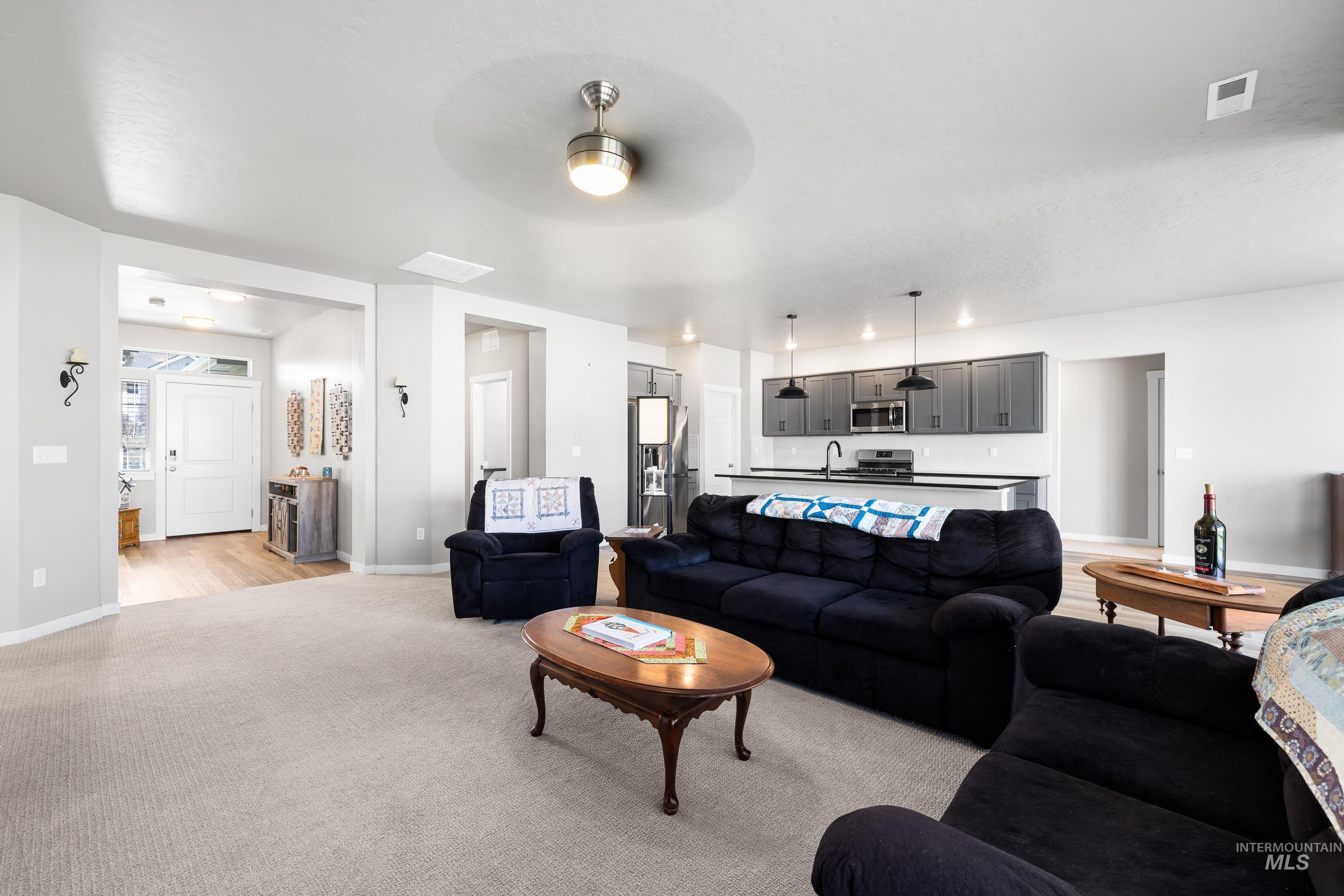 Living room featuring light colored carpet and ceiling fan