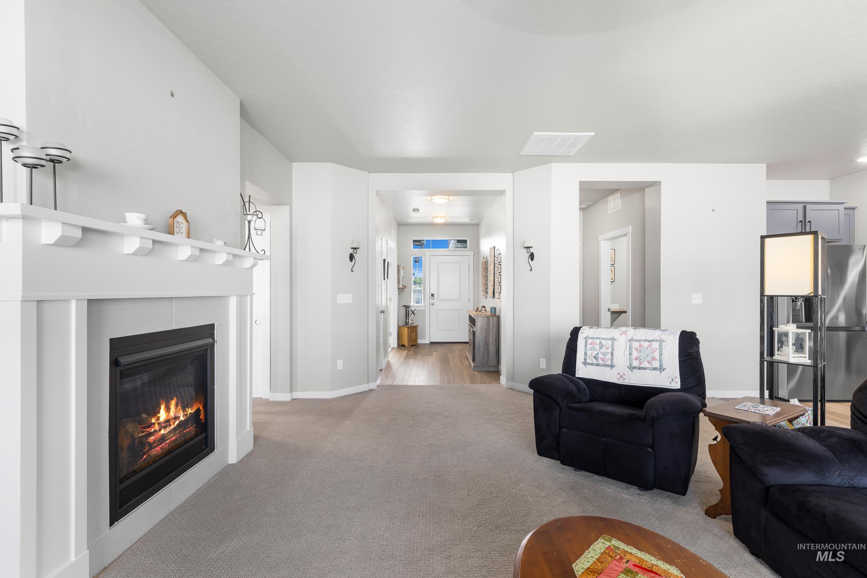 Living room with carpet and a fireplace