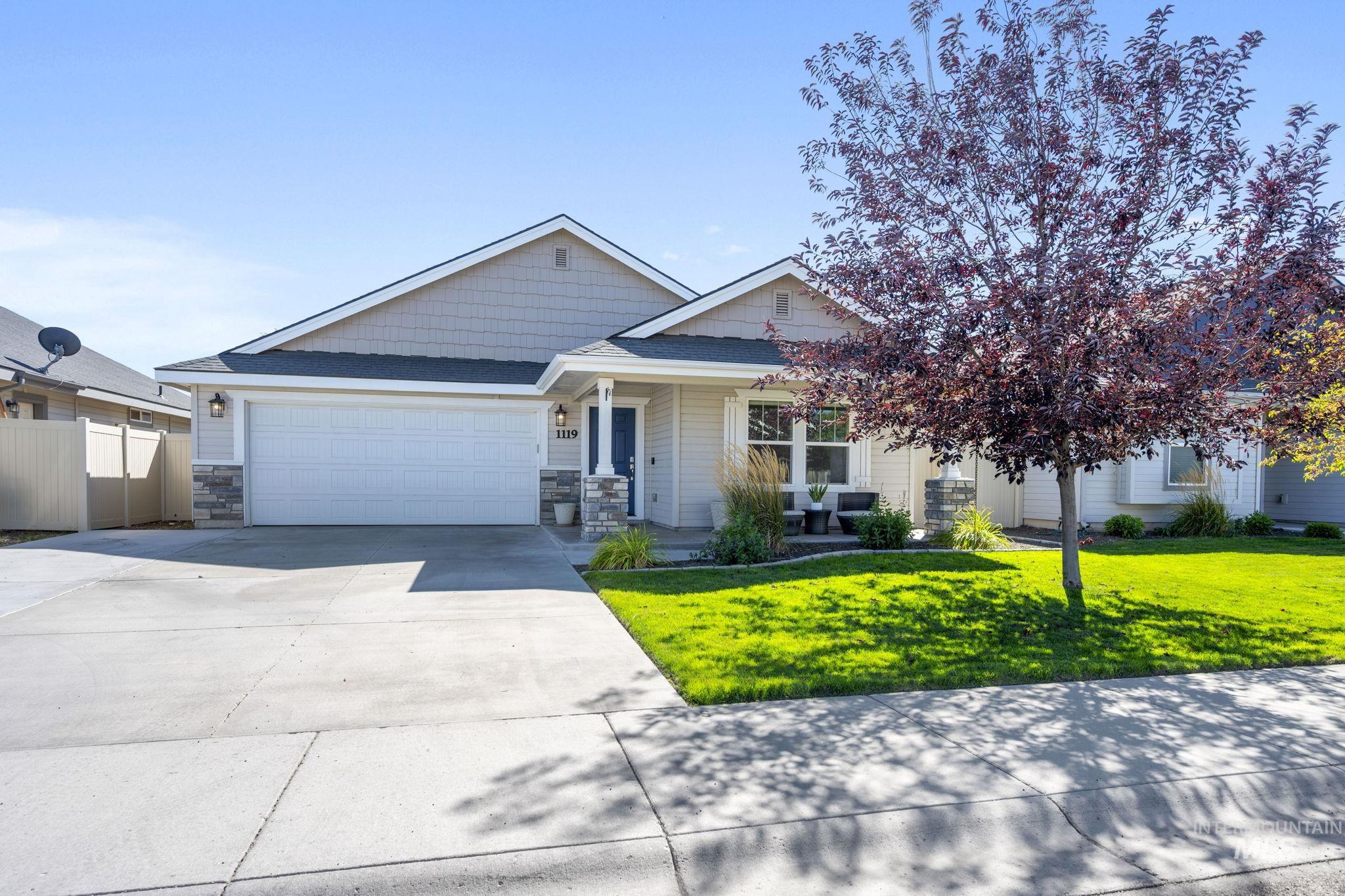 Craftsman-style home with concrete driveway, stone siding, and a garage