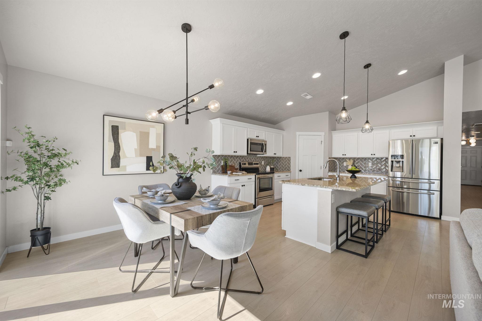Dining area featuring a chandelier, light wood-type flooring, lofted ceiling, and recessed lighting