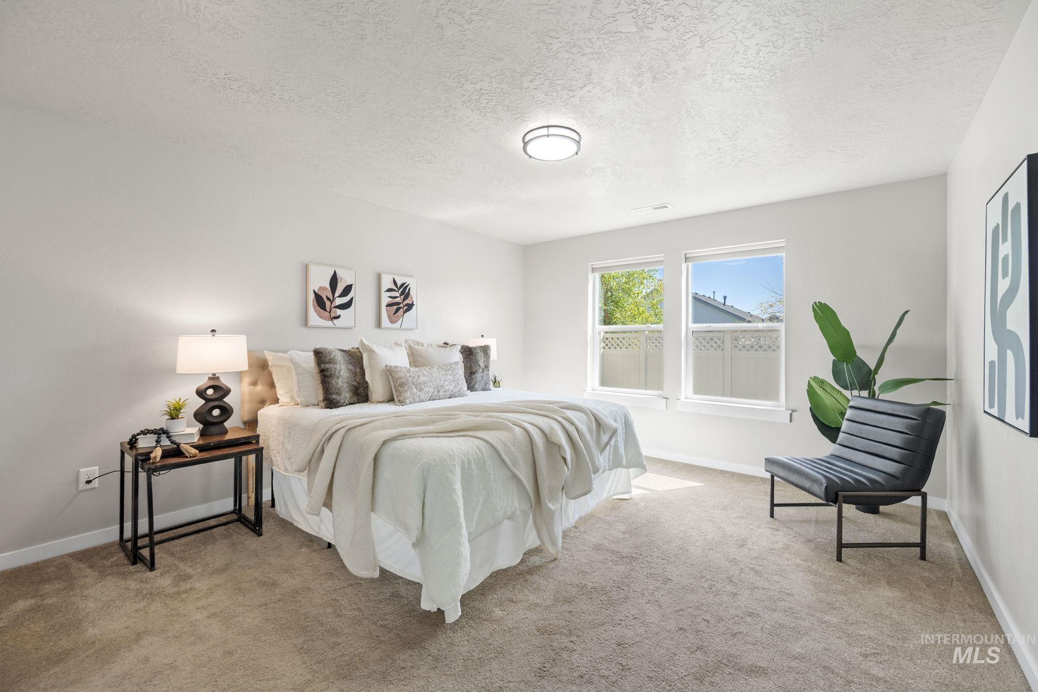 Bedroom featuring light carpet and a textured ceiling