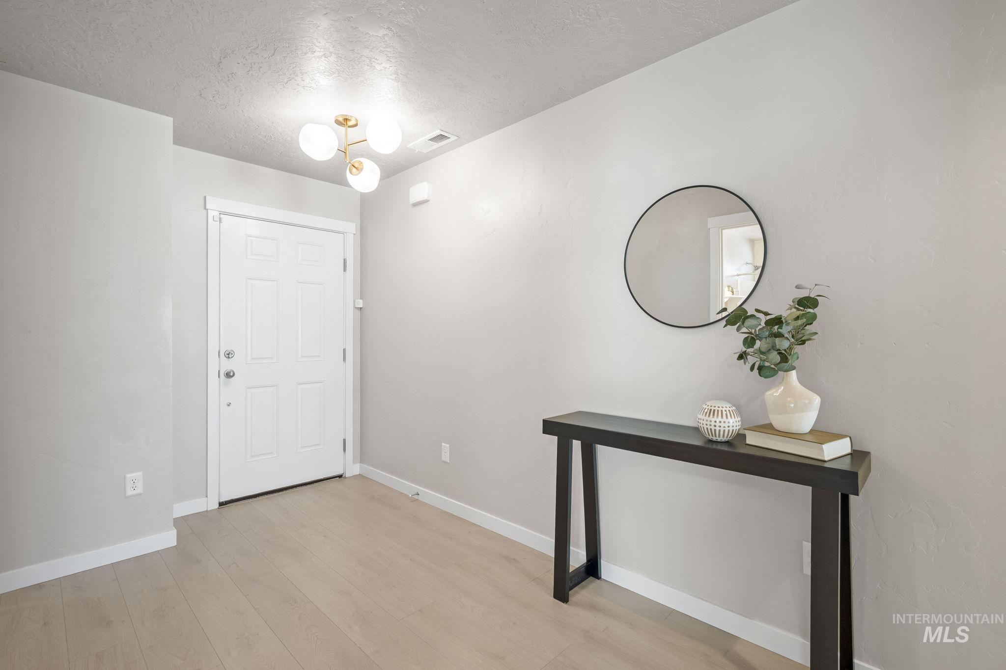 Entrance foyer featuring a textured ceiling and light wood-style flooring