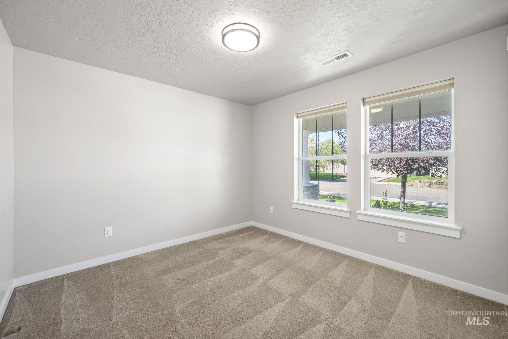 Unfurnished bedroom featuring light colored carpet, a closet, and a textured ceiling