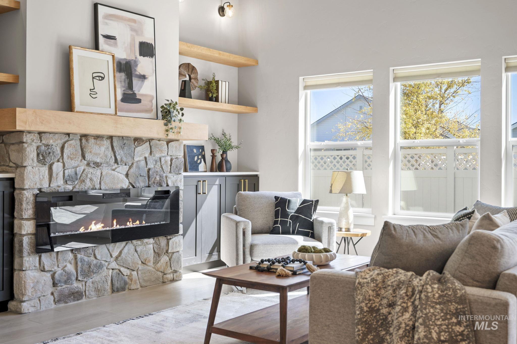 Living room with wood finished floors and a stone fireplace