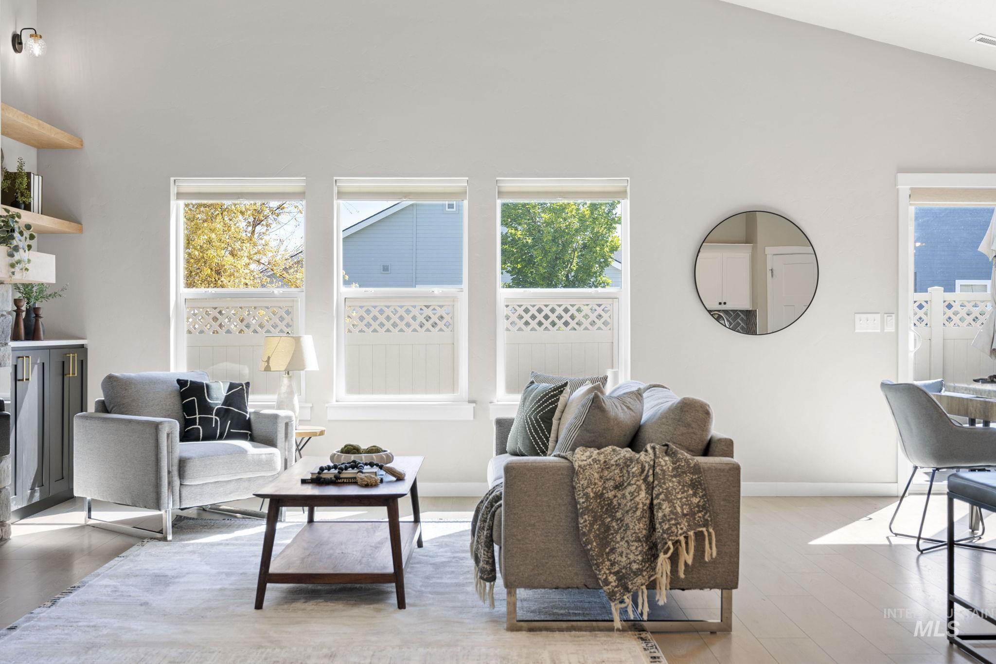 Living area with high vaulted ceiling and light wood finished floors