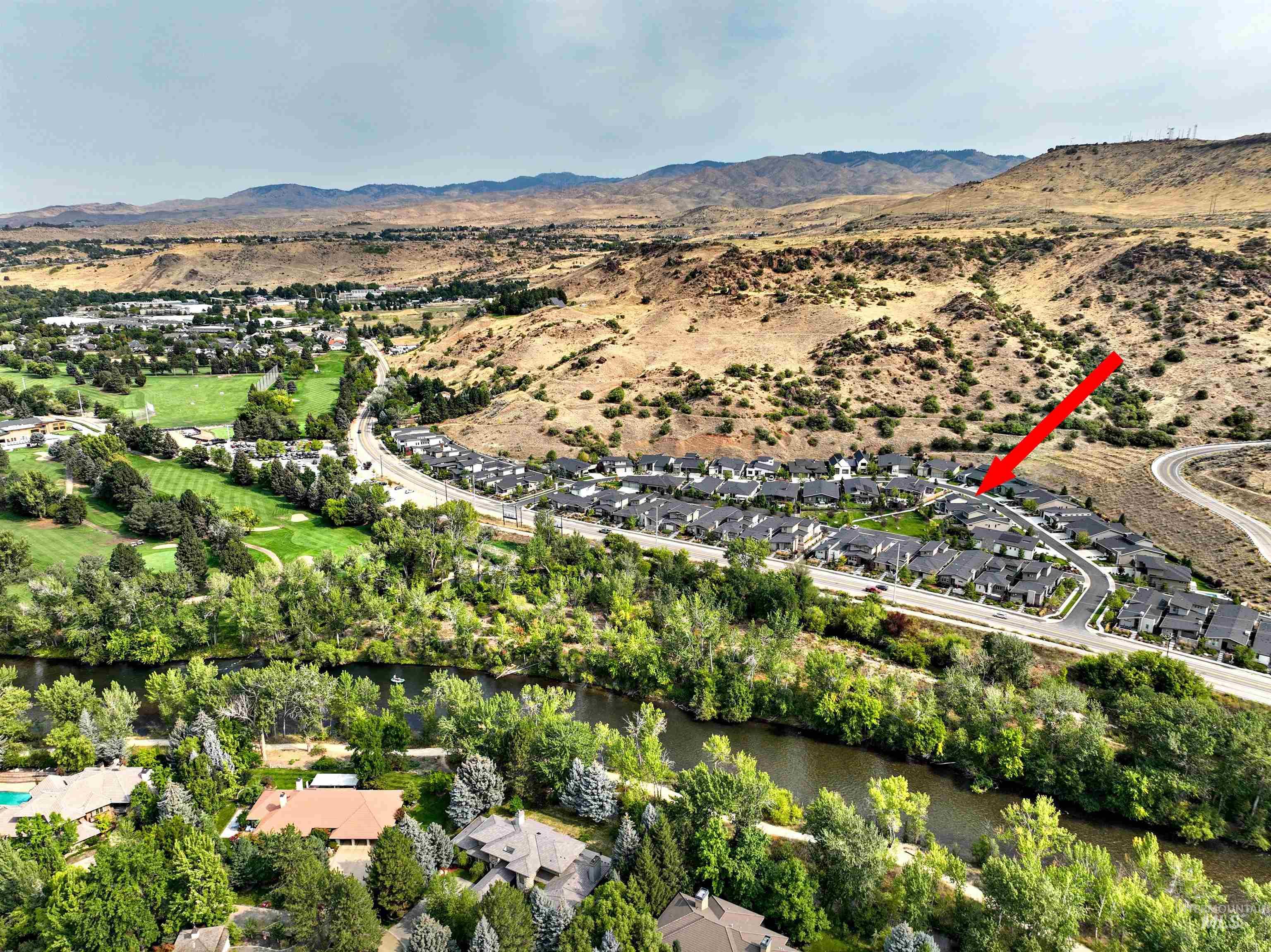 Aerial overview of property's location featuring nearby suburban area and mountains