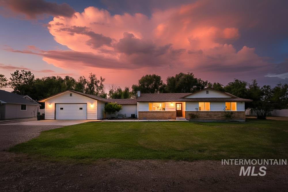 Ranch-style home with driveway, a front lawn, and brick siding
