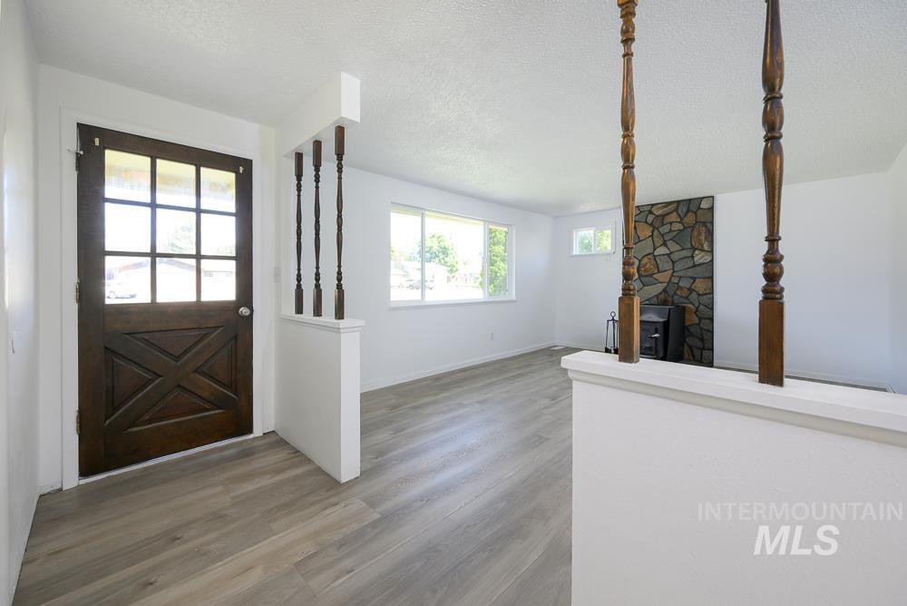 Foyer entrance with a textured ceiling, wood finished floors, and a fireplace