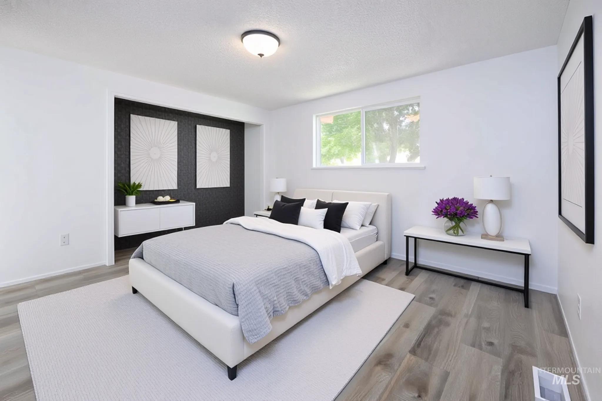 Bedroom with wood finished floors and a textured ceiling
