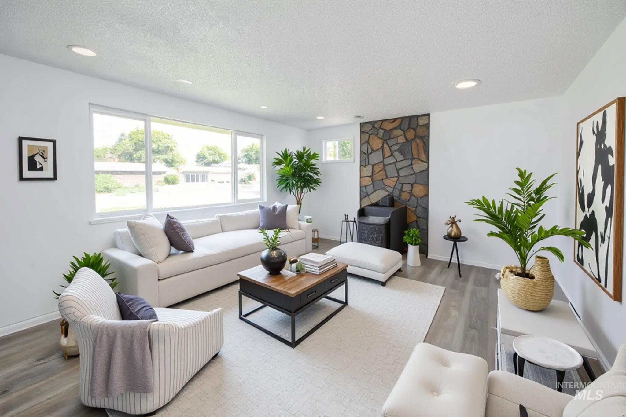 Living area featuring wood finished floors, a textured ceiling, recessed lighting, and a fireplace