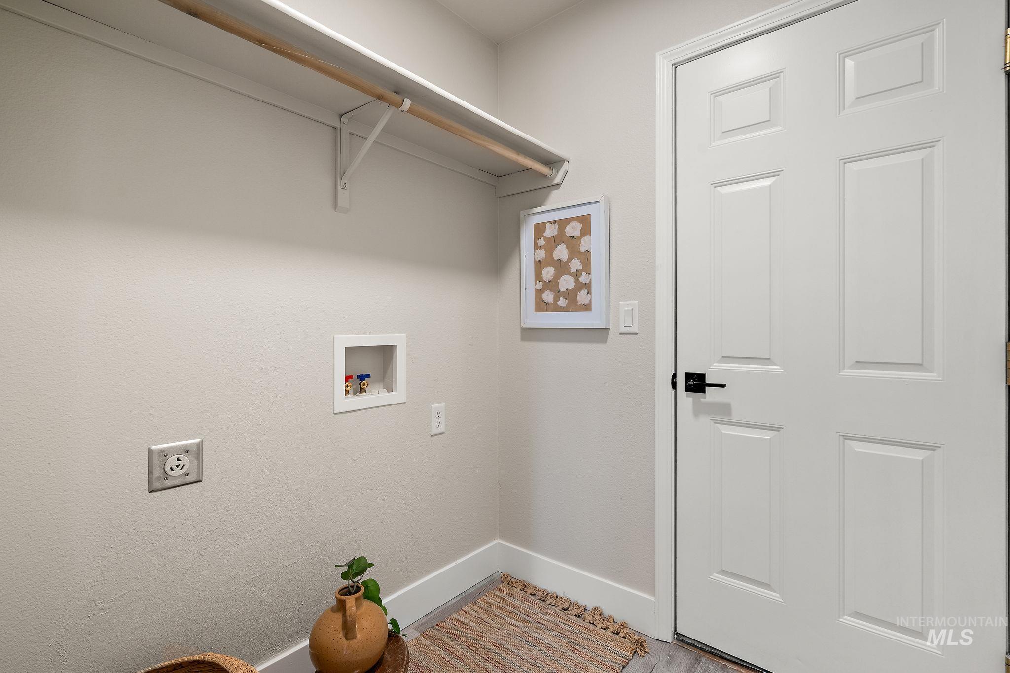 Washroom featuring hookup for a washing machine, wood finished floors, and electric dryer hookup