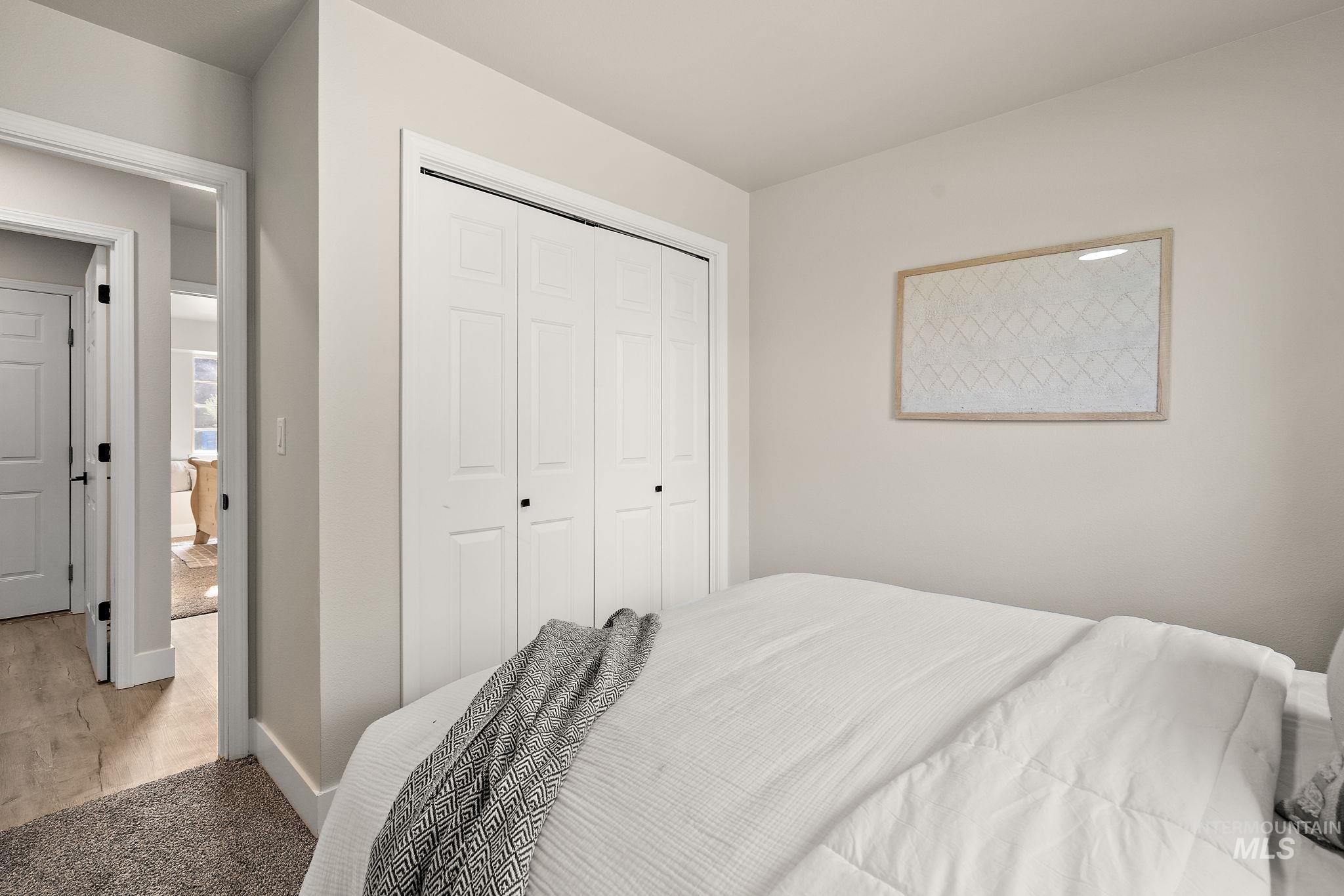 Carpeted bedroom with a closet and baseboards