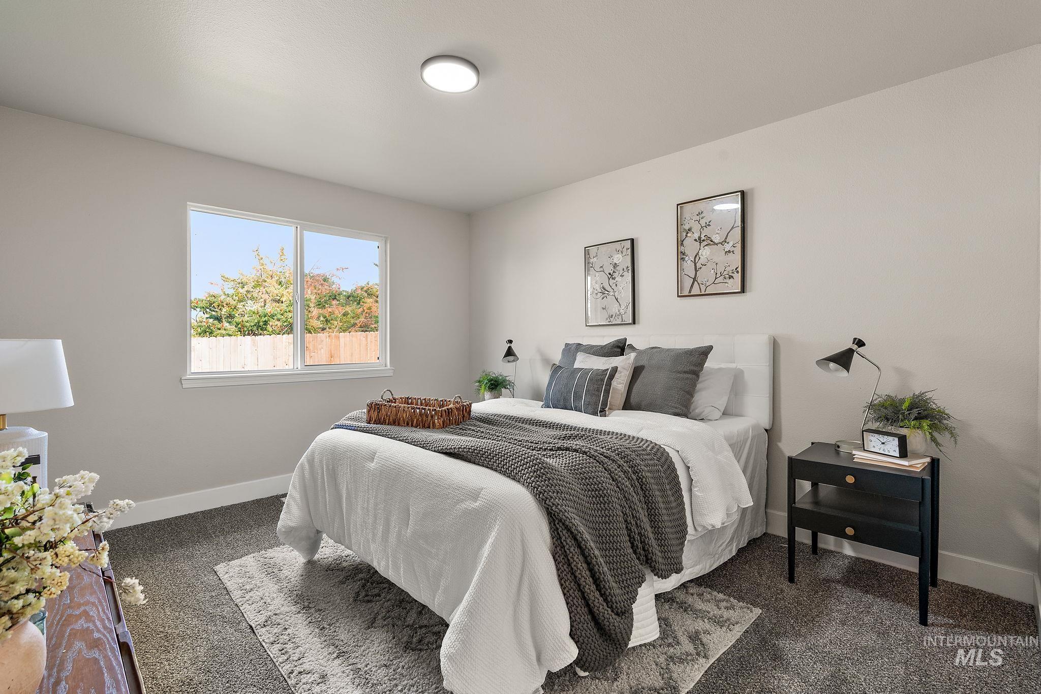 Bedroom featuring baseboards and dark carpet