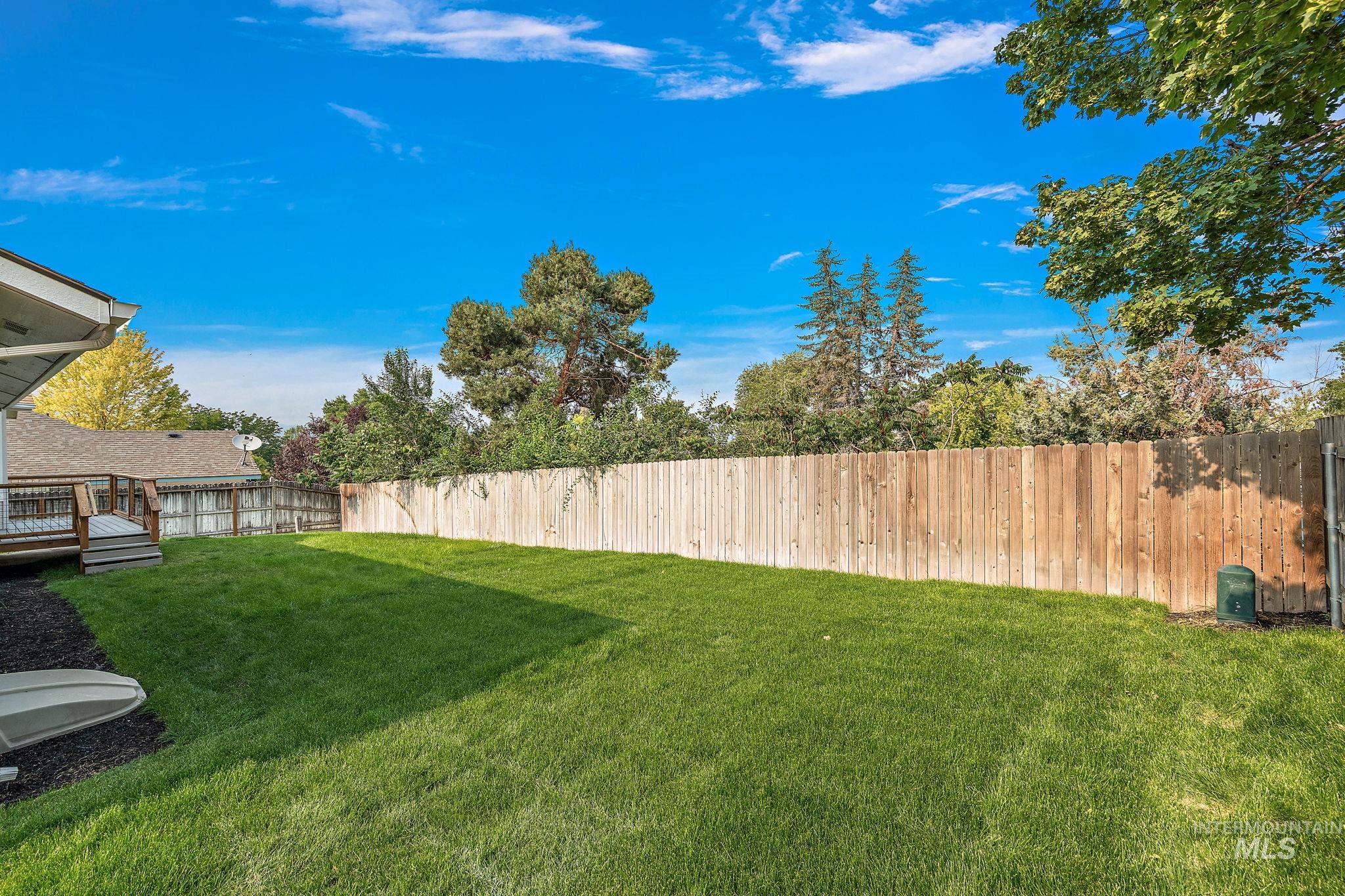 Fenced backyard with a wooden deck