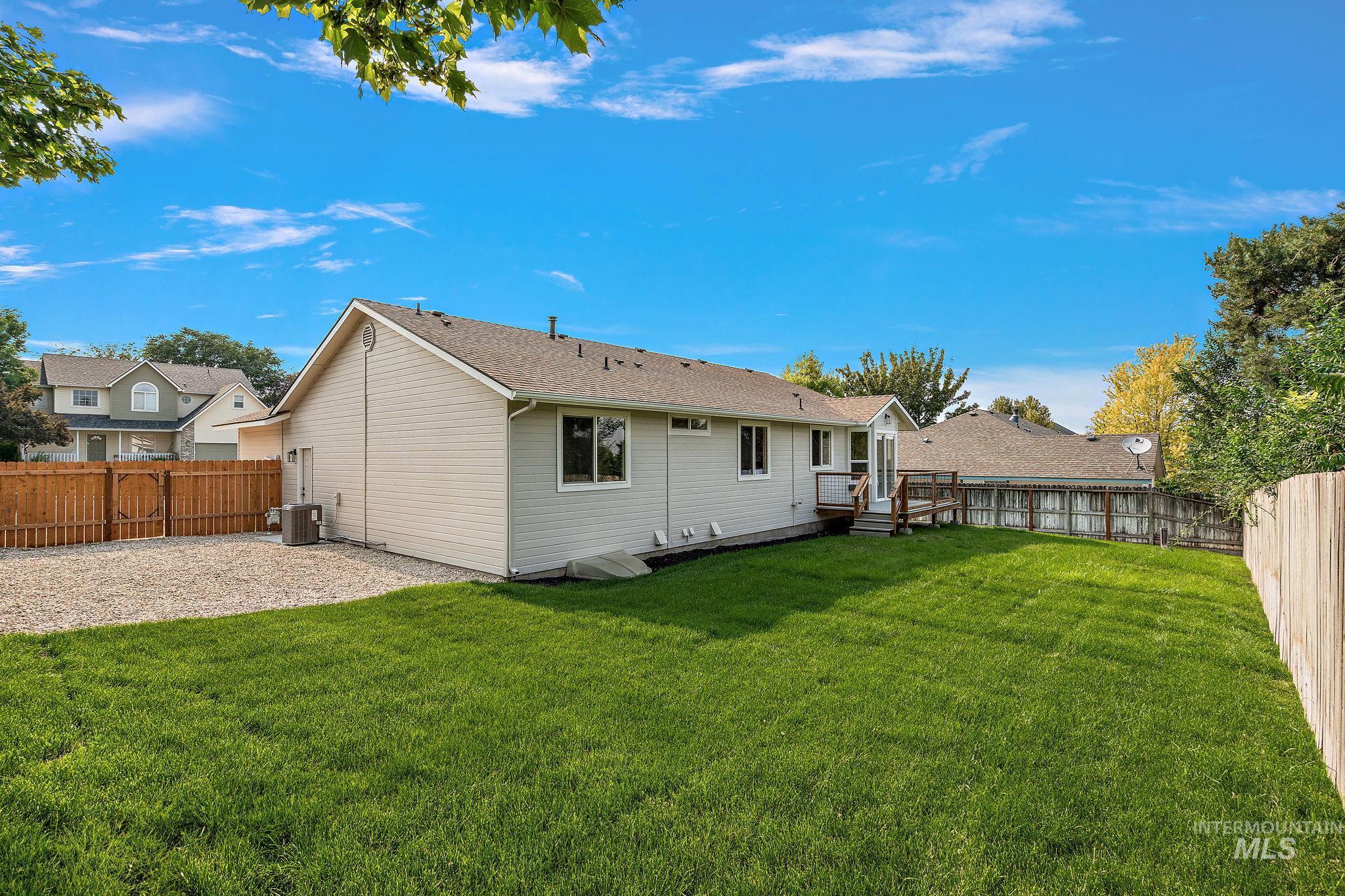 Rear view of house featuring a fenced backyard and a deck