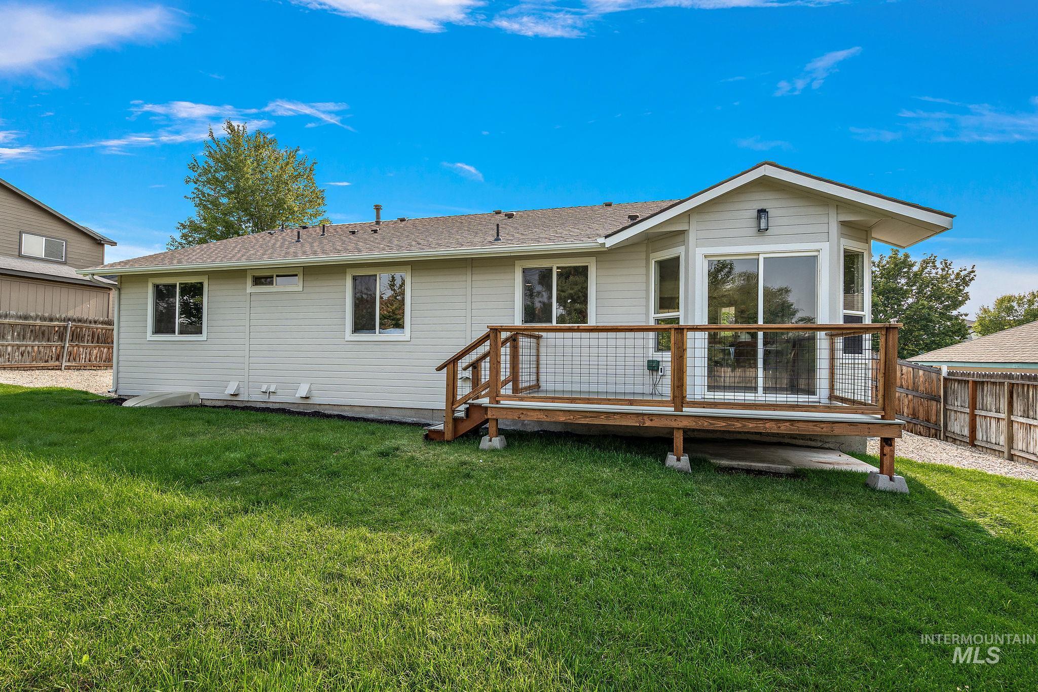 Back of property featuring a deck and roof with shingles
