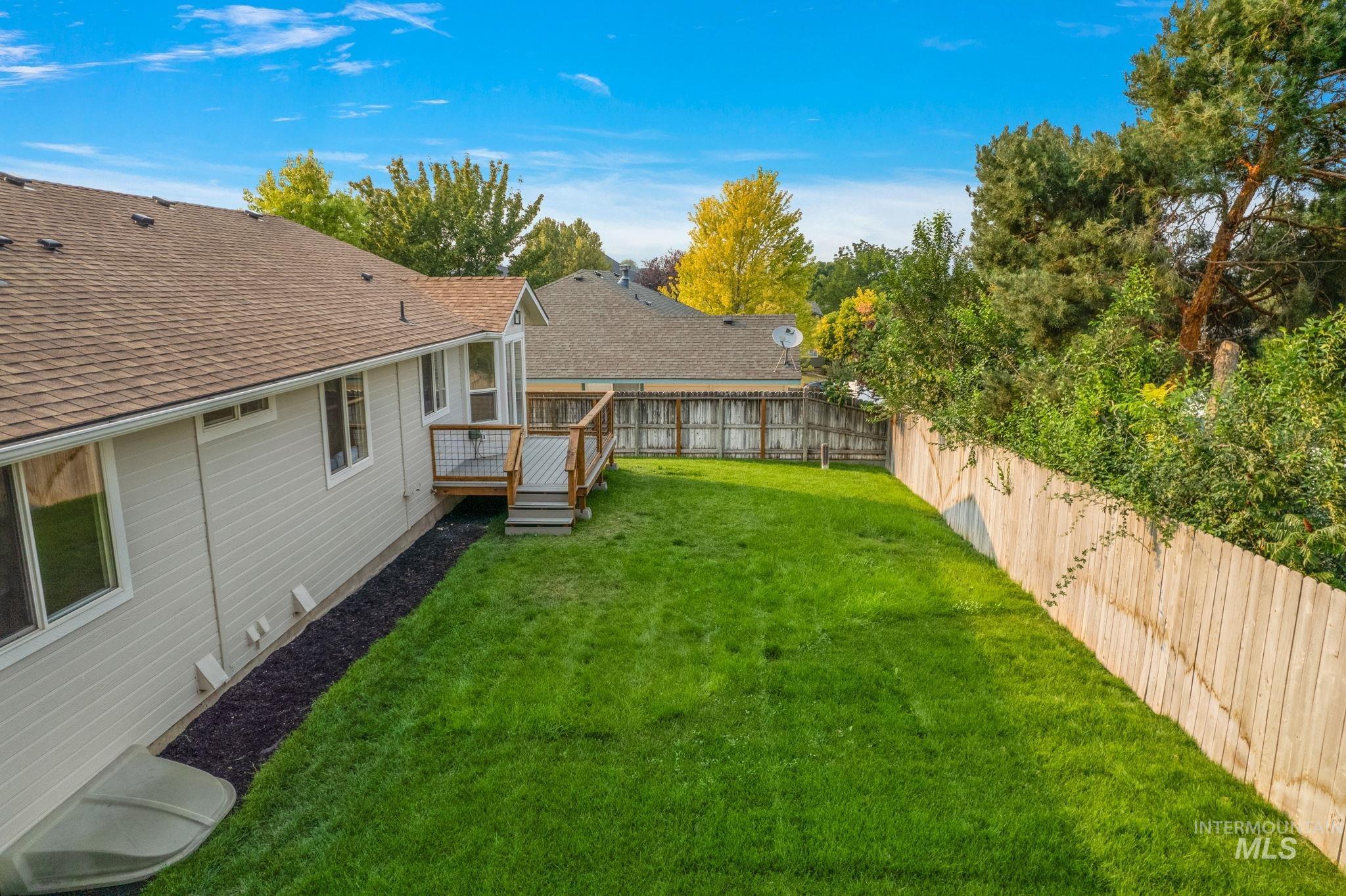 Fenced backyard with a deck