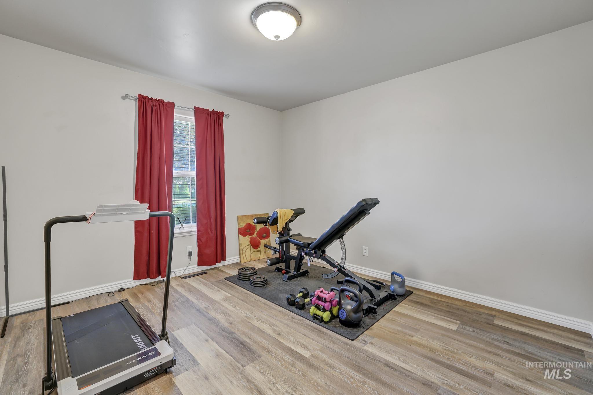 Exercise area featuring light wood-style flooring