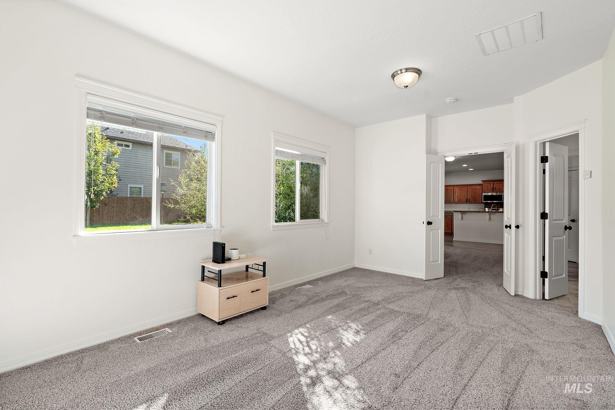 Unfurnished bedroom featuring light carpet and baseboards