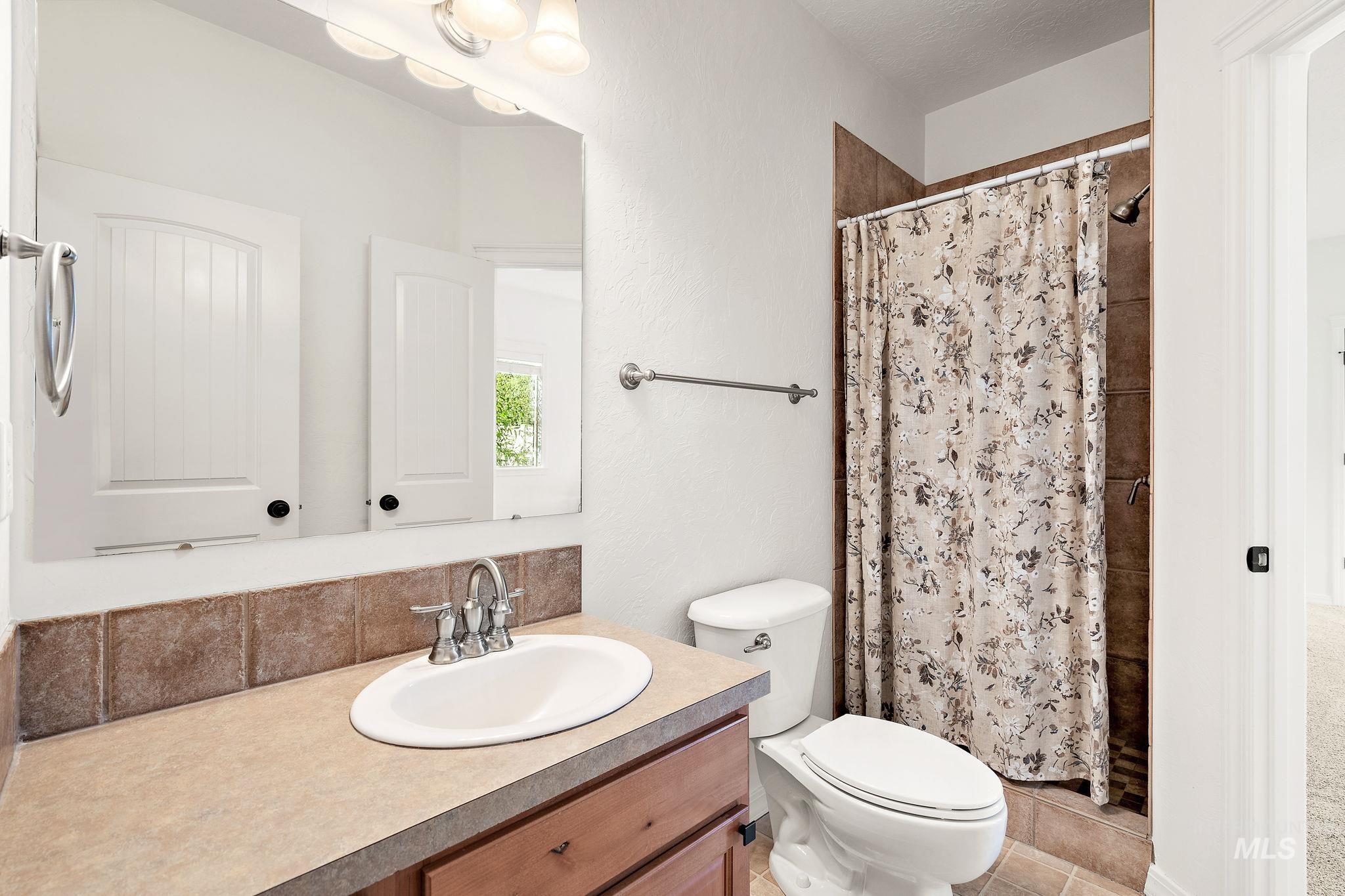 Full bathroom featuring vanity, a shower with curtain, and light tile patterned floors