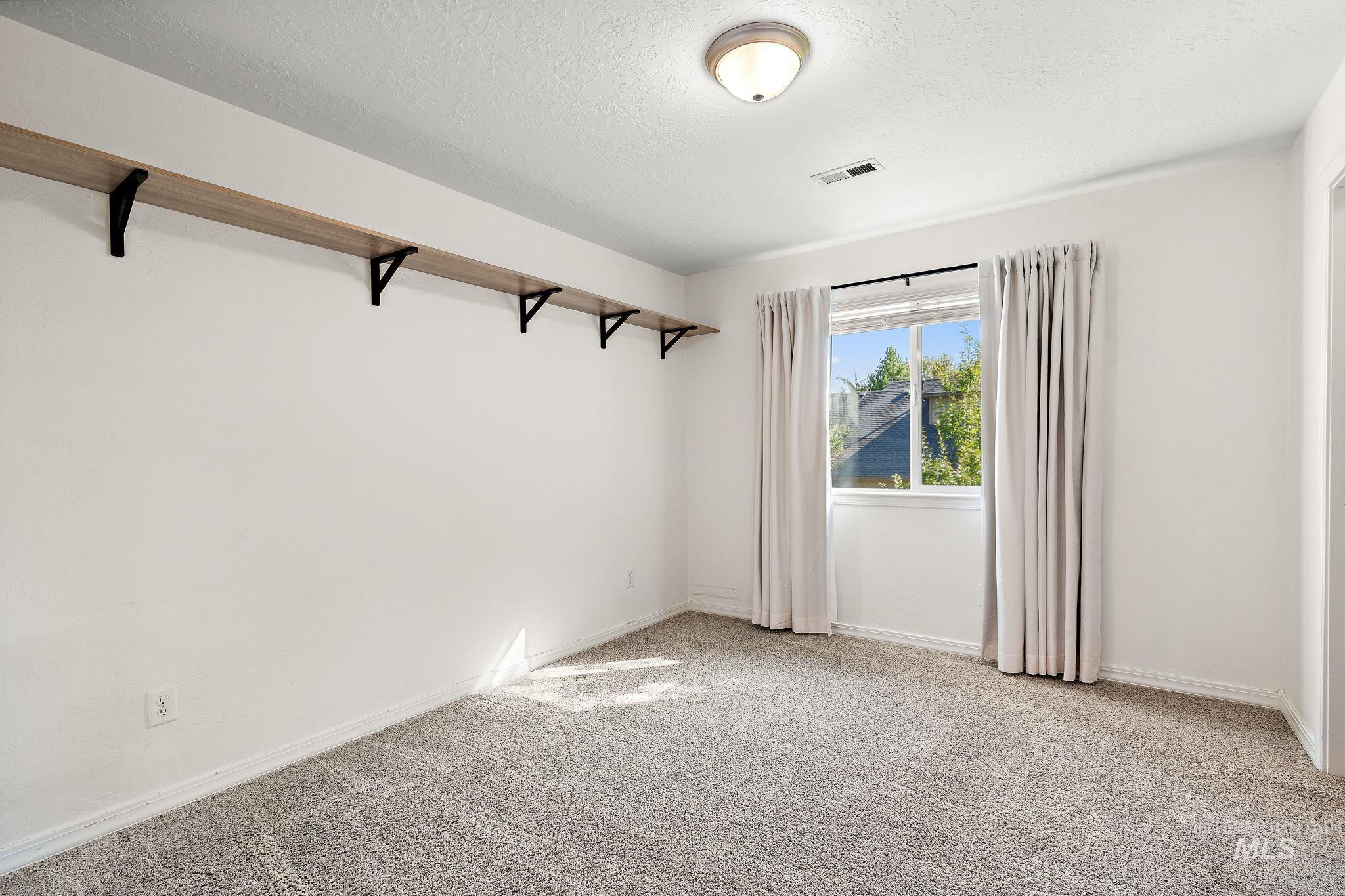 Spare room with light colored carpet and a textured ceiling