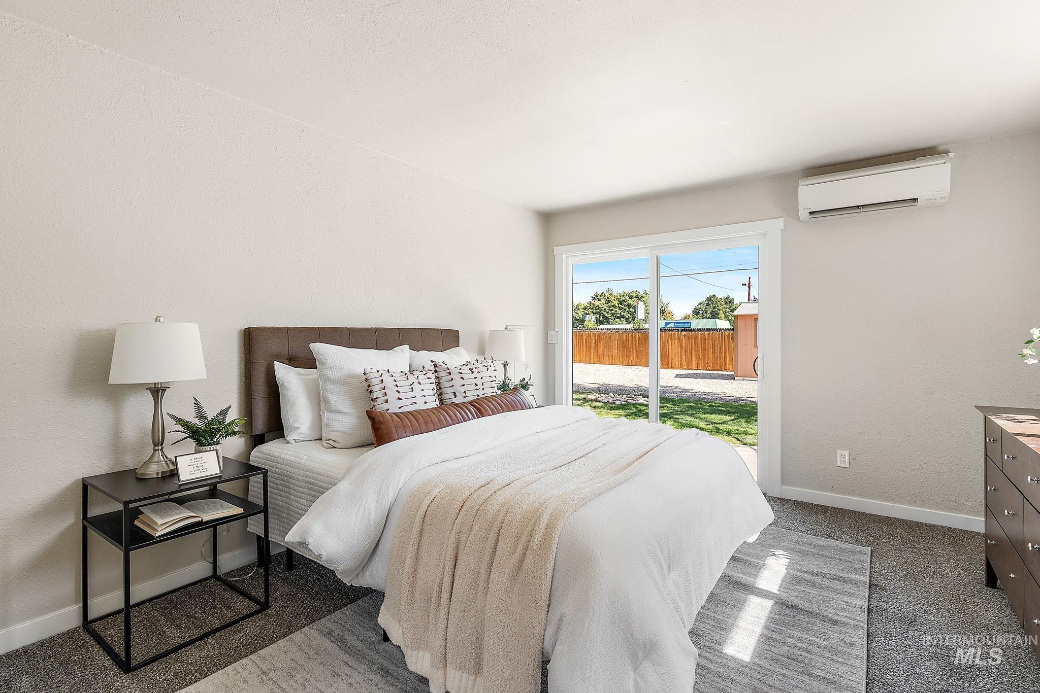 Bedroom featuring access to outside, a wall mounted AC, and carpet