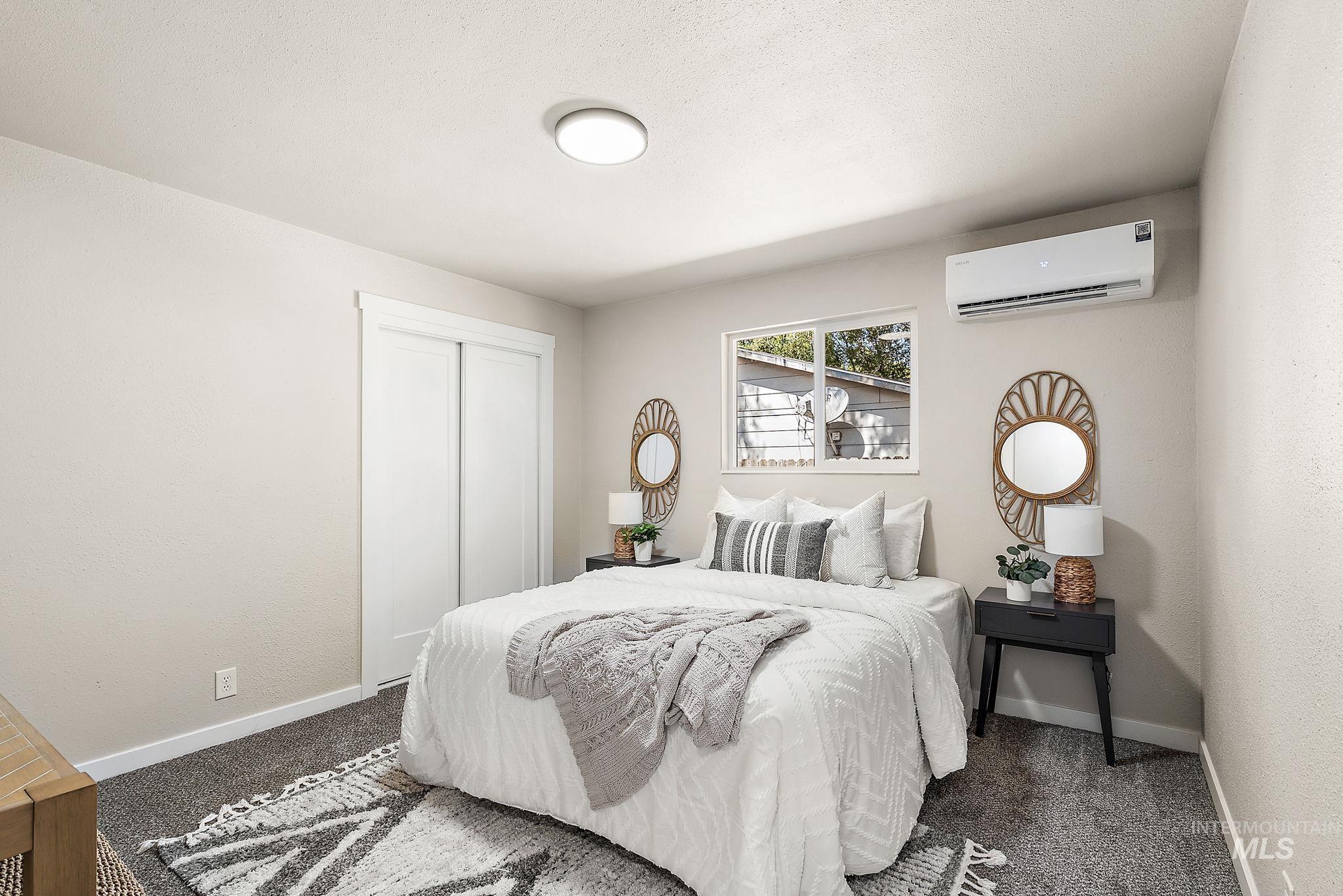 Bedroom featuring a closet, a wall mounted air conditioner, and carpet floors