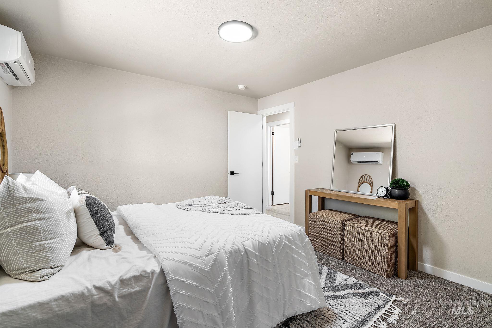 Bedroom featuring carpet floors and a wall unit AC