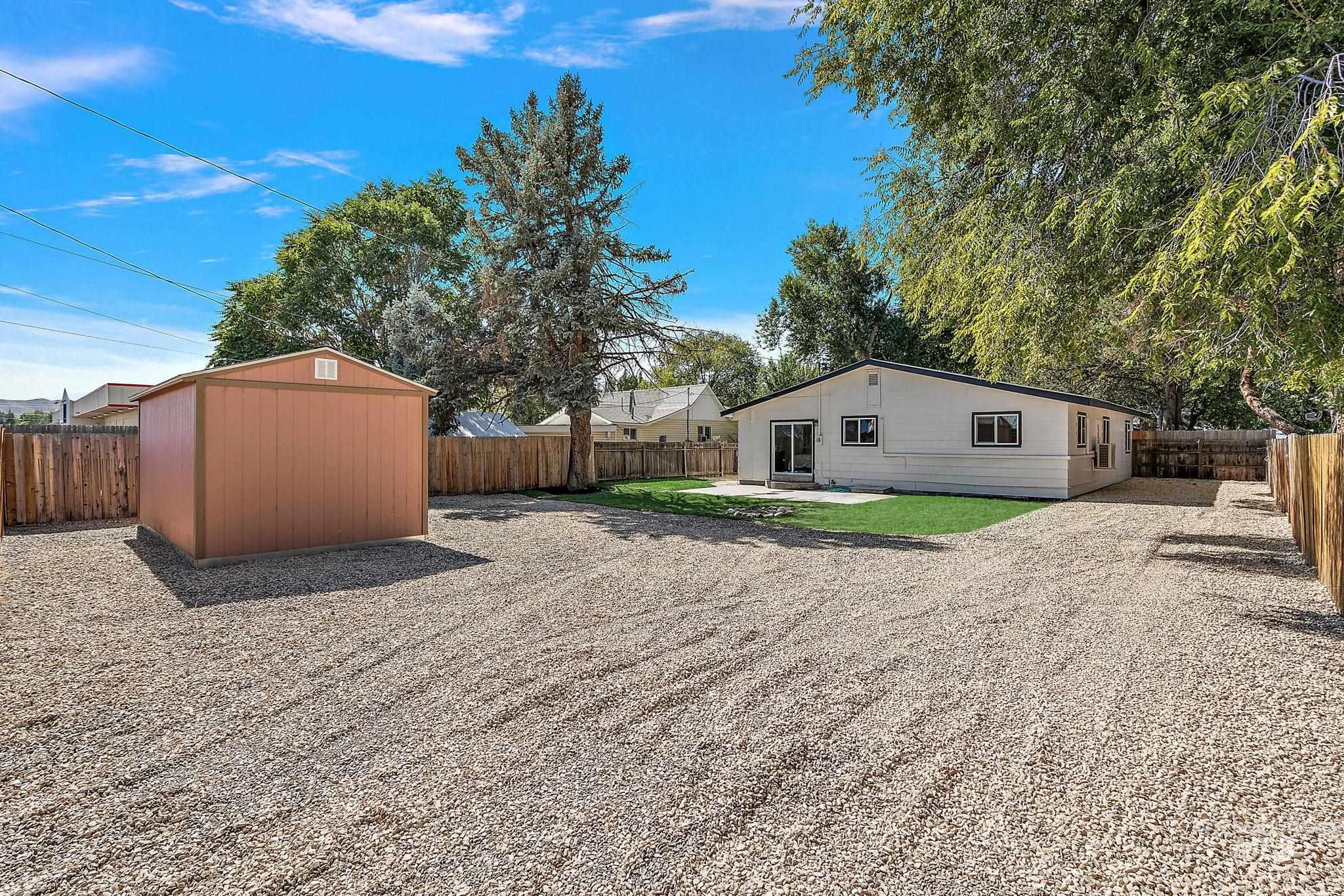Fenced backyard with a patio area and a storage shed
